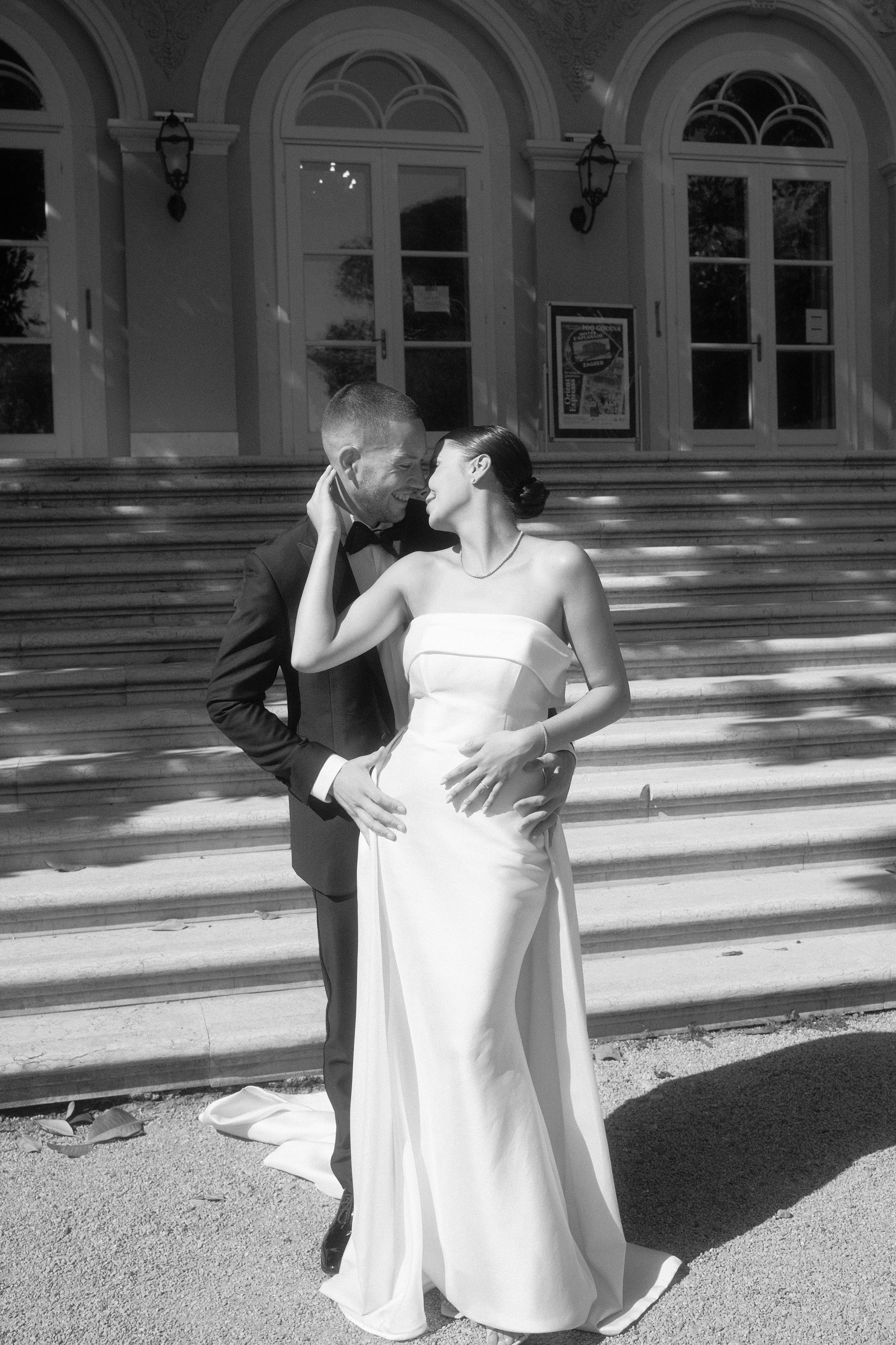 Bride and groom standing together in front of a lighthouse