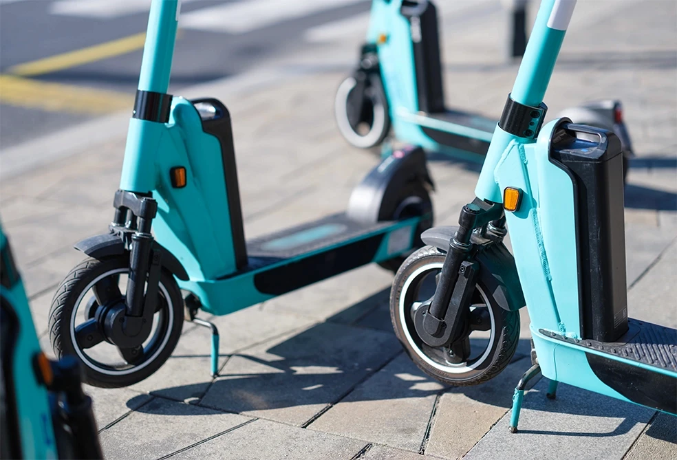 Close-up of rental scooter wheels parked on Stockton sidewalk