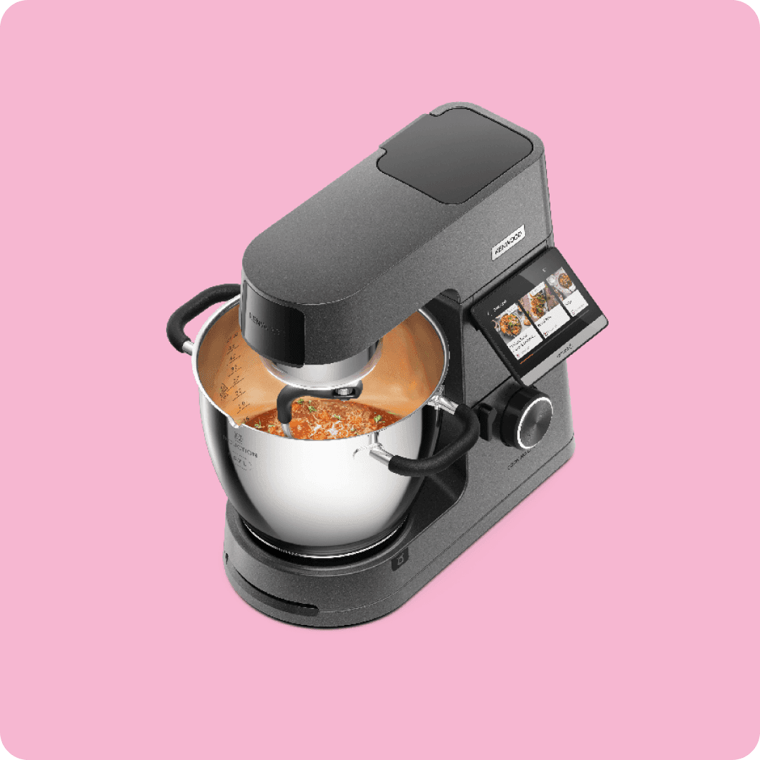 Smart stand mixer with built in screen stirs food in a metal bowl while displaying recipe steps