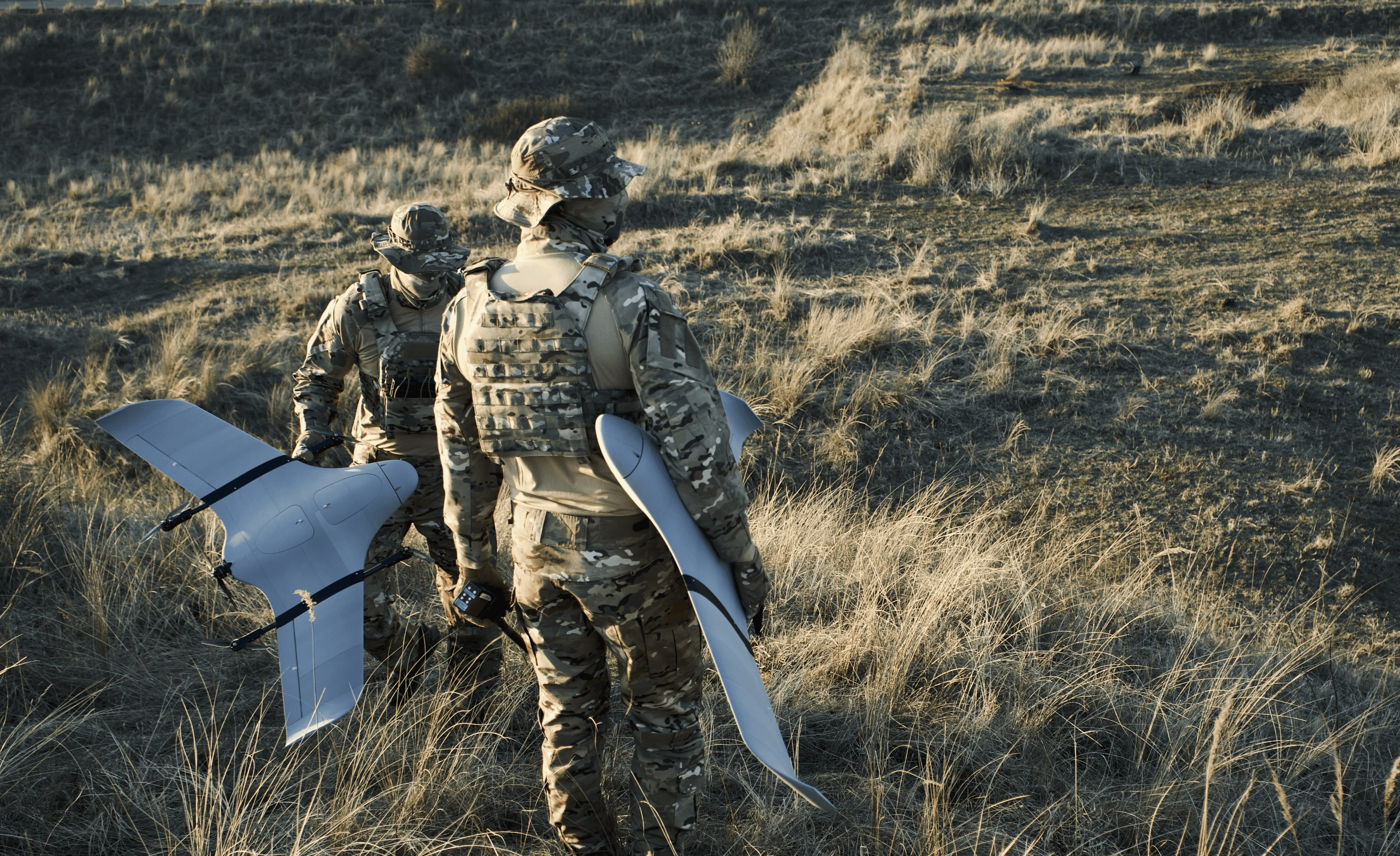 two soldiers in the field with a VTOL drone in their hands