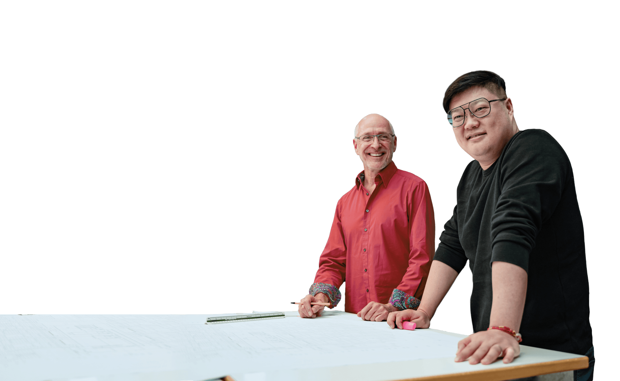 Zwei Architekten stehen gemeinsam an einem Planungstisch vor dem modernen Bürogebäude der kba Architekten und Ingenieure GmbH; sie lächeln in die Kamera und arbeiten an Bauzeichnungen, die professionelle Zusammenarbeit und architektonische Kompetenz vermitteln.