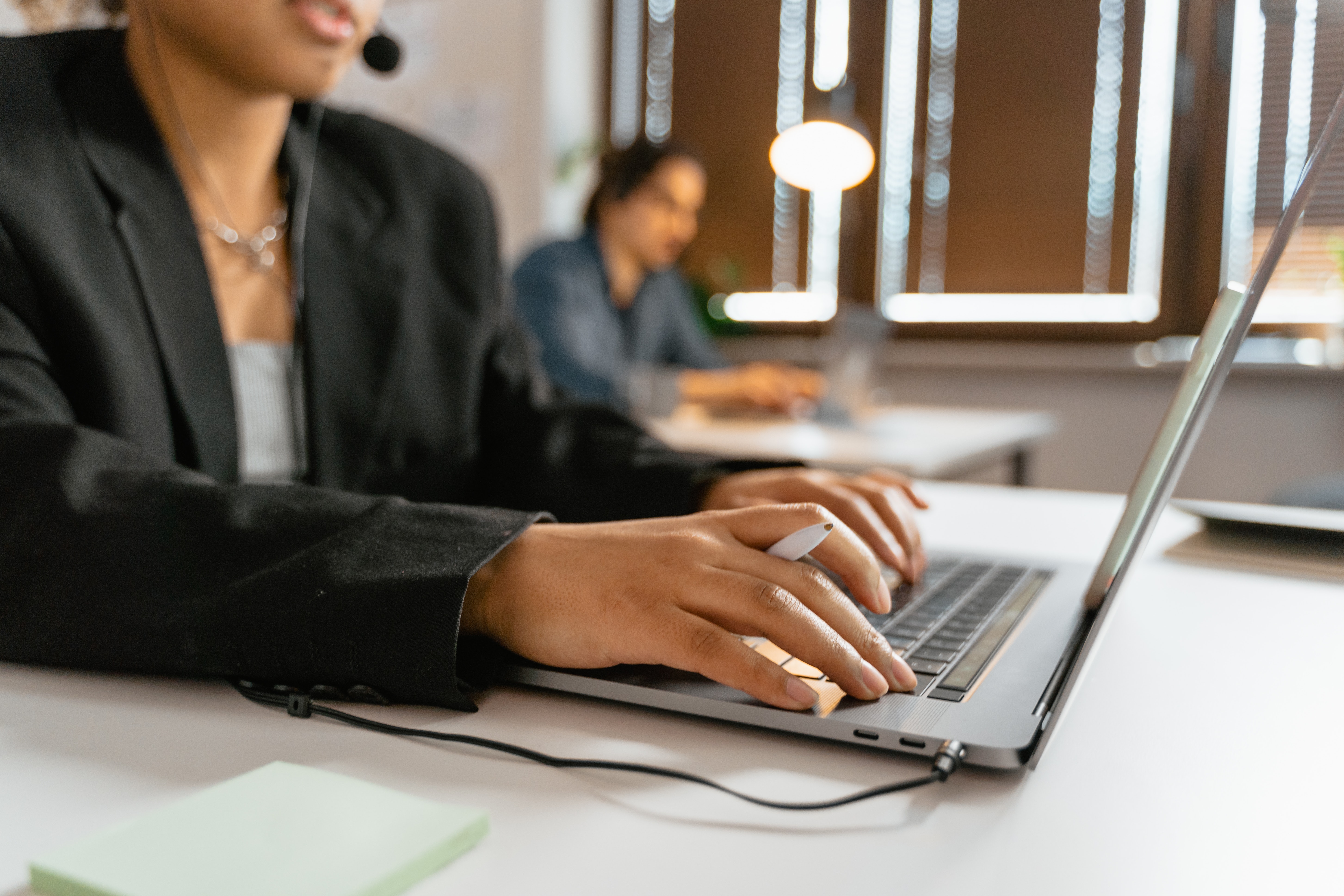 customer support person typing on phone holding a pen