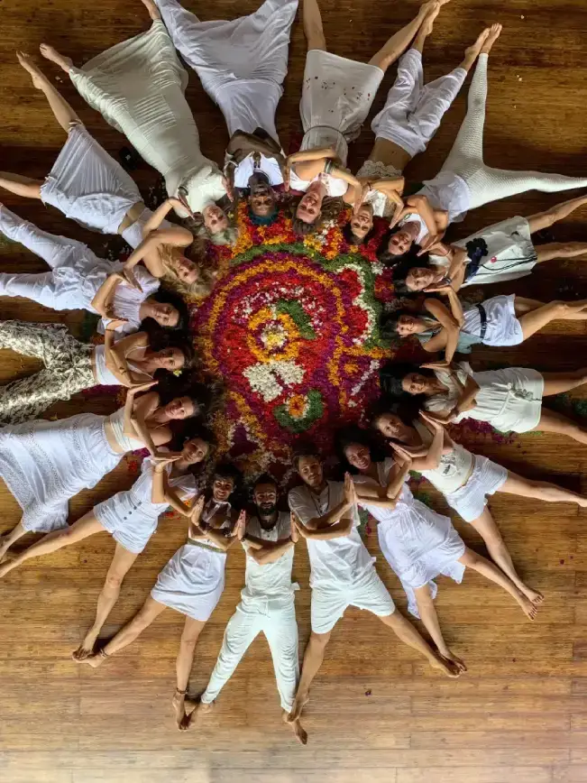 Yoga teacher training community holding hands in a sunset circle during a nature excursion in Bali