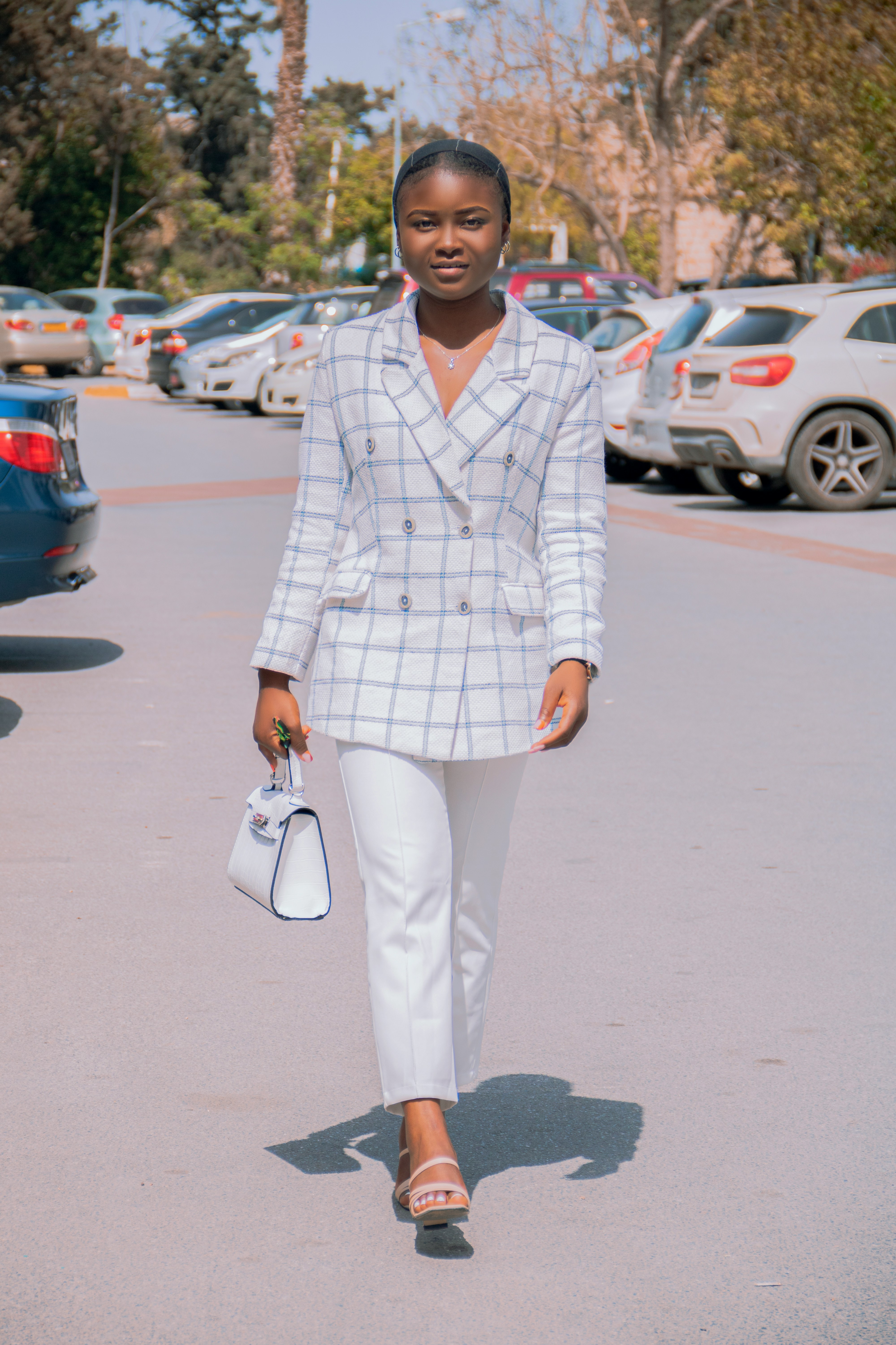 a woman walking down a street holding a purse