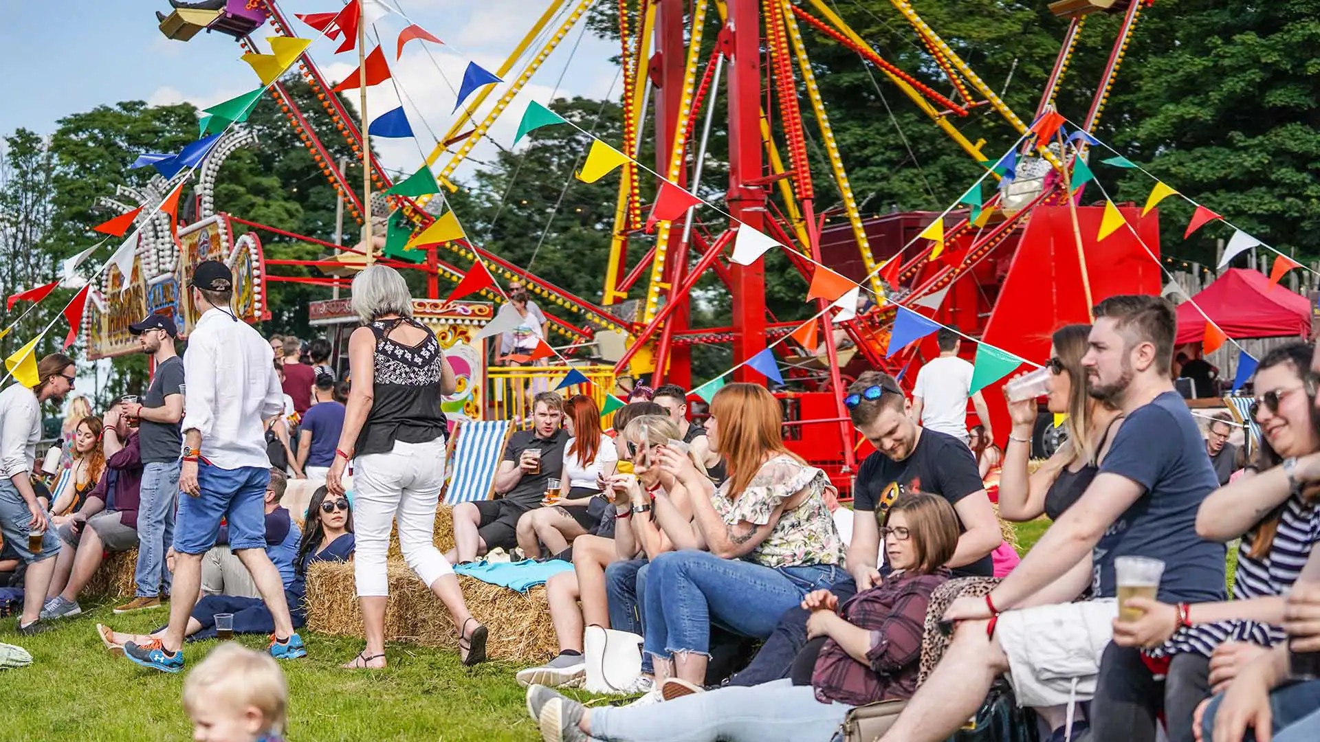 People at a summer with bunting and rides