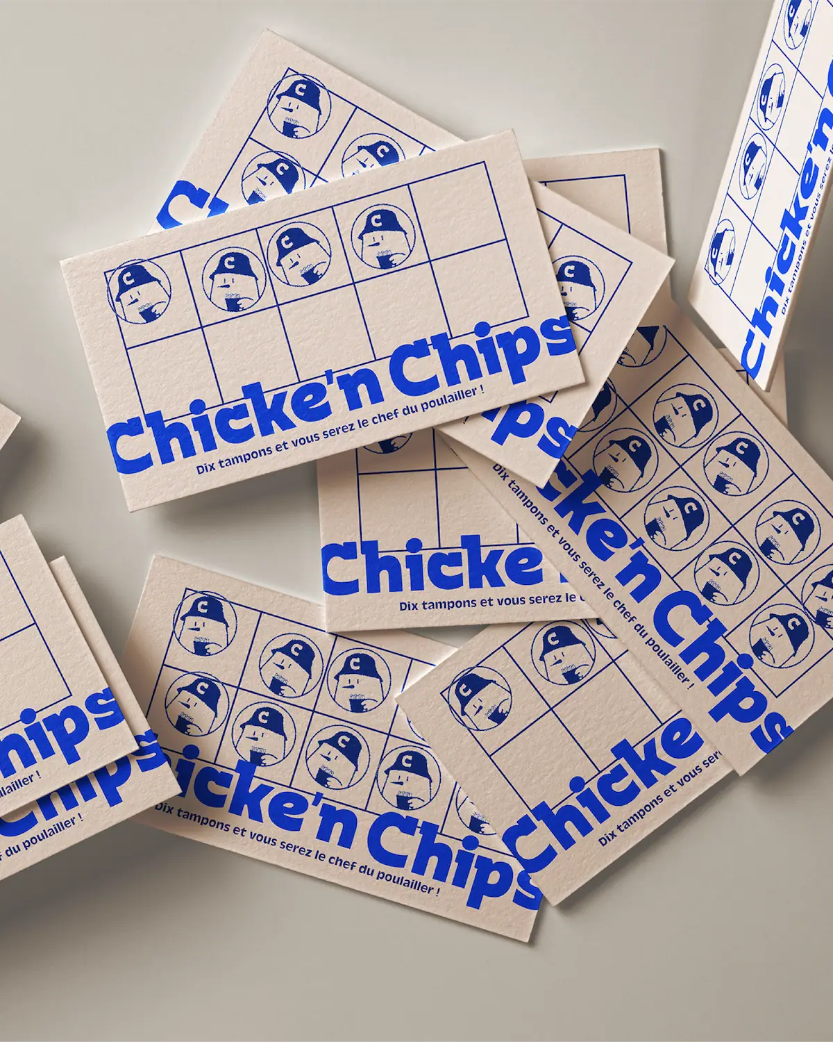 Cartes de fidélité Chicke'n Chips éparses, impression bleue sur carton crème avec grille de tampons et mascotte illustrée.