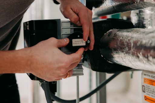 Close up of fingers working on a technical sensor