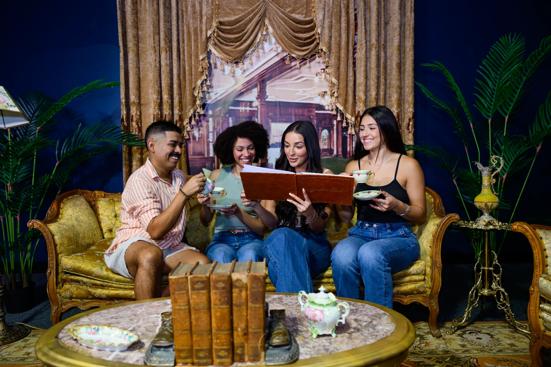 Four guests seated on antique furniture examining a book in a Victorian-styled immersive experience room