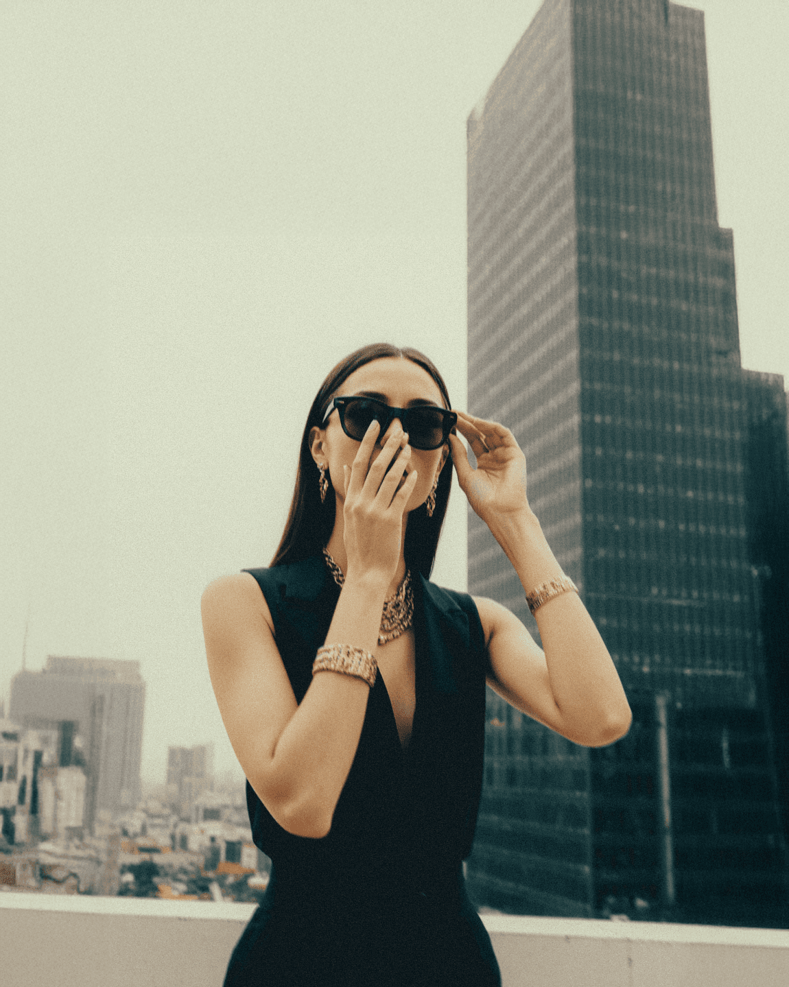 Model posing a roof top wearing sunglasses
