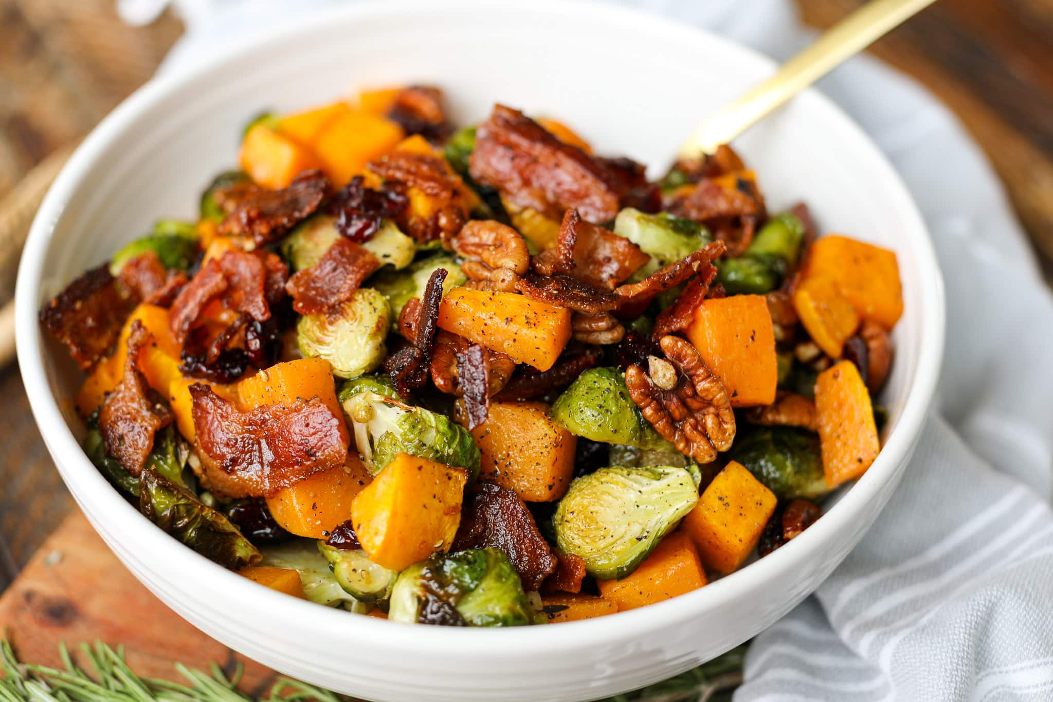 A vibrant dish of roasted Brussels sprouts and butternut squash, mixed with shallots, fresh herbs, and a medley of spices.