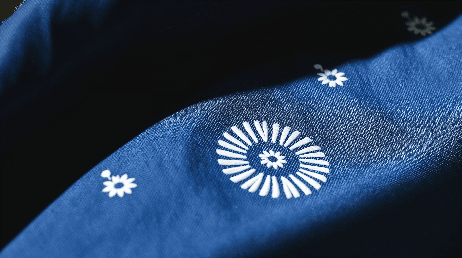 A closeup of a sashiko stitching on an indigo colored garment.