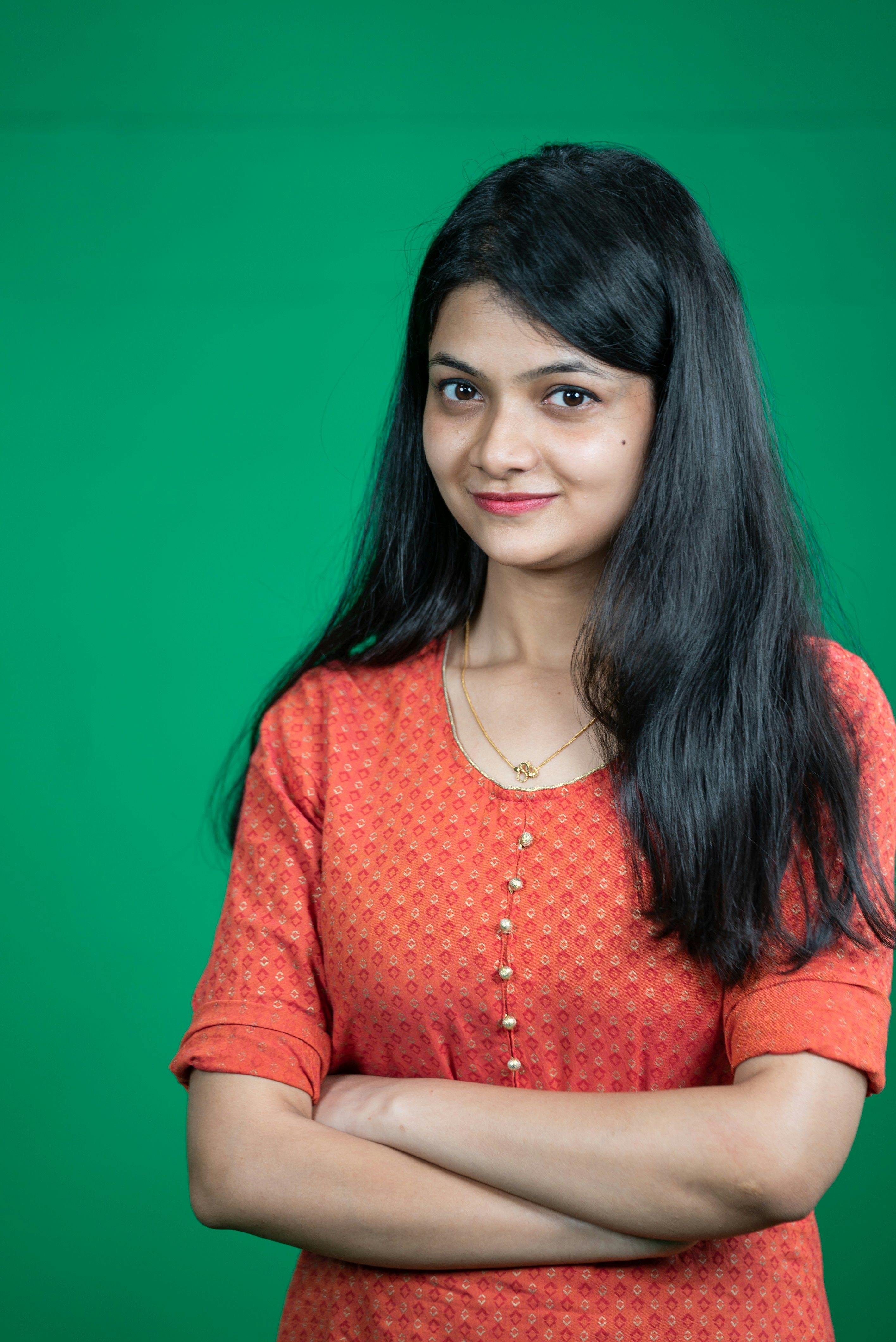a woman with long black hair standing with her arms crossed