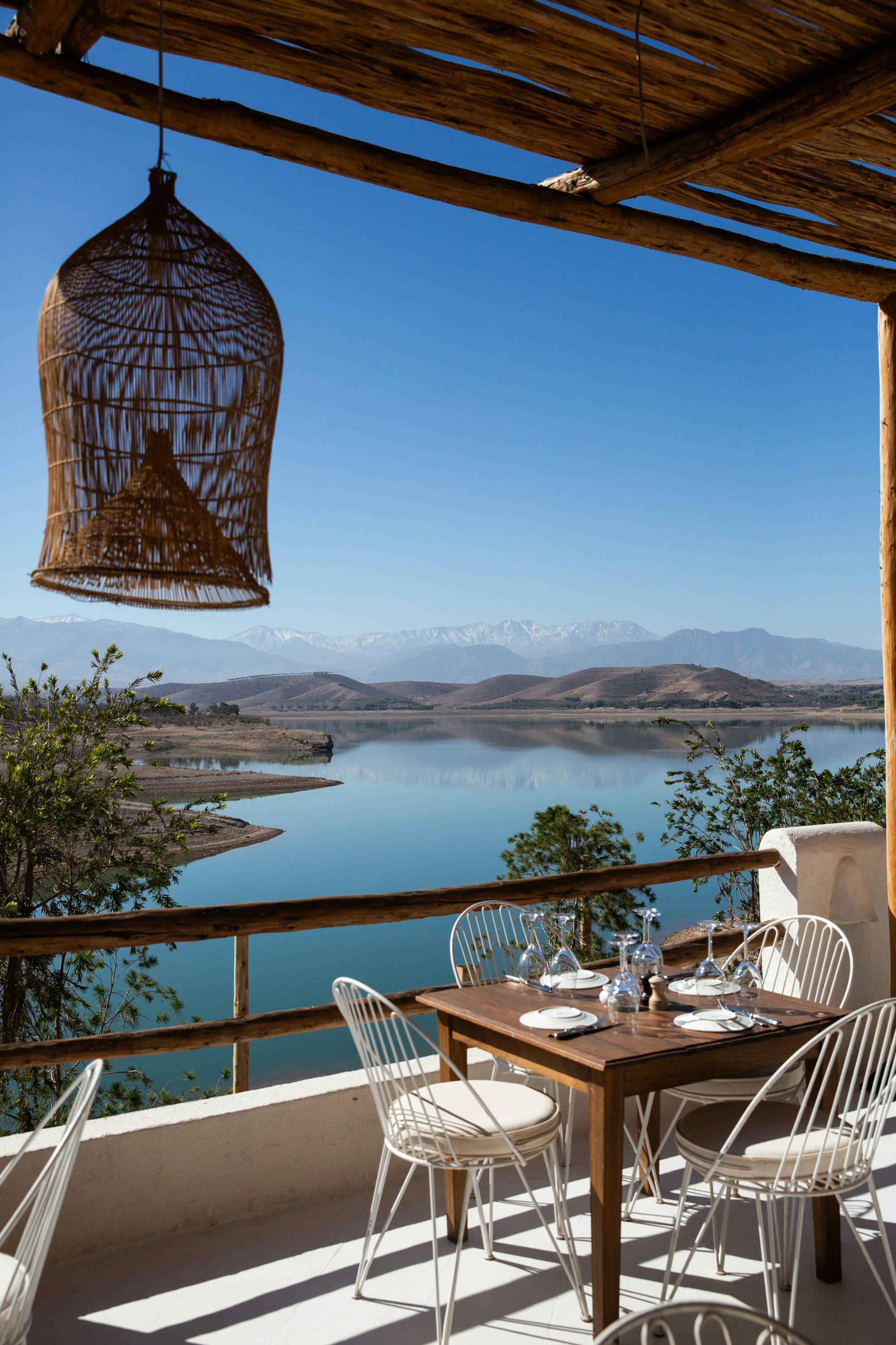 Restaurant terrace overlooking a lake and mountain range.