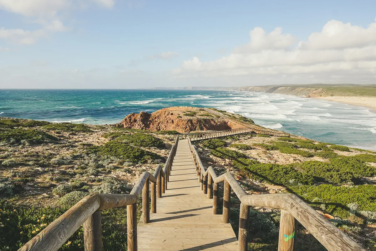 Wooden boardwalk leading toward an Algarve beach.