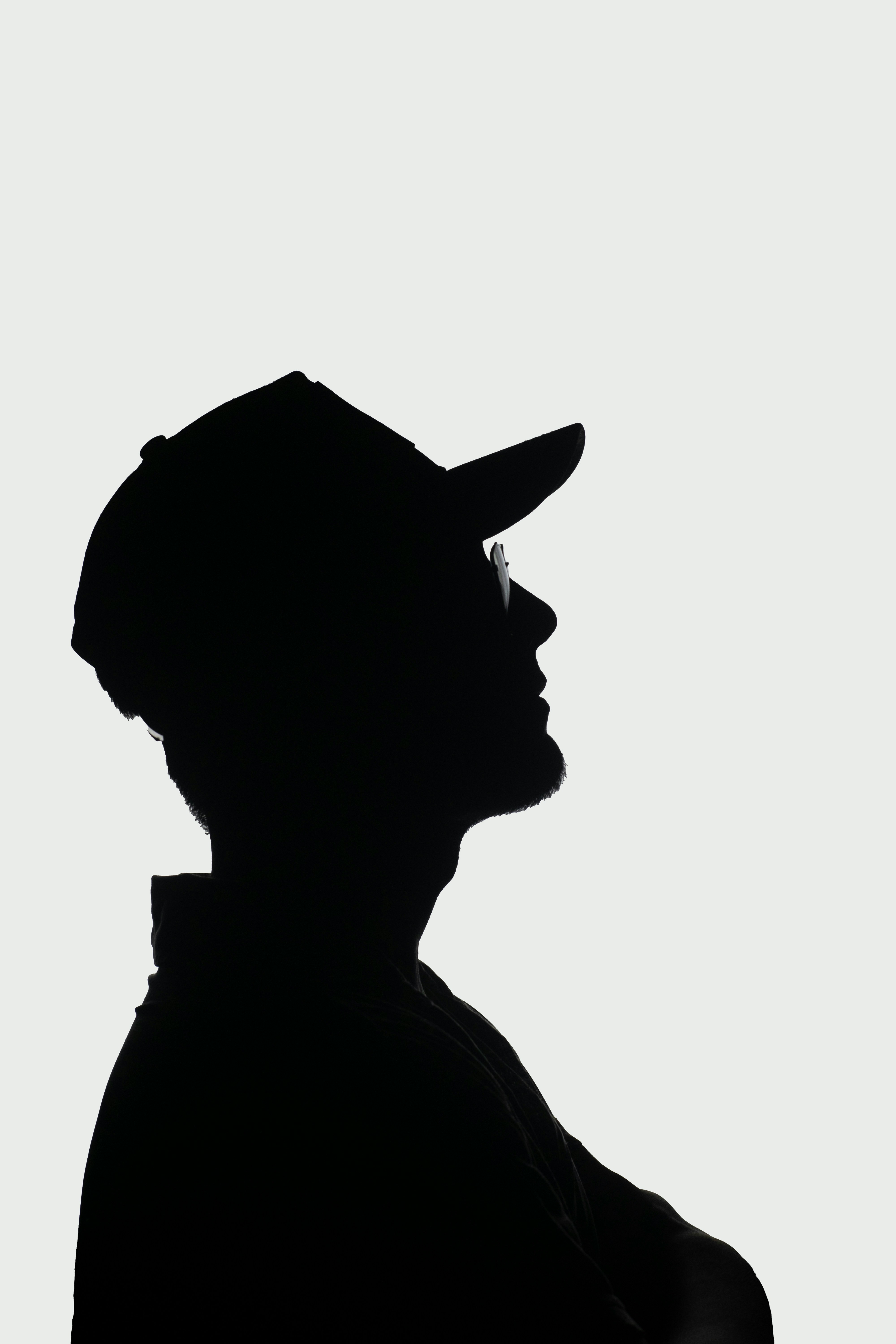 a silhouette of a man wearing a hat