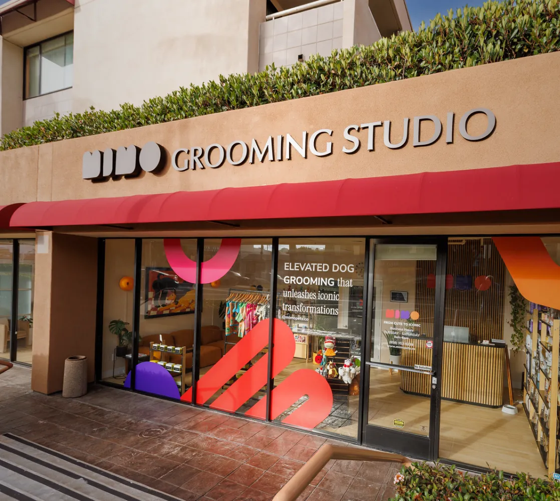 Mimo Grooming Studio storefront with a red awning and colorful window graphics, dog groomer on La Jolla Blvd