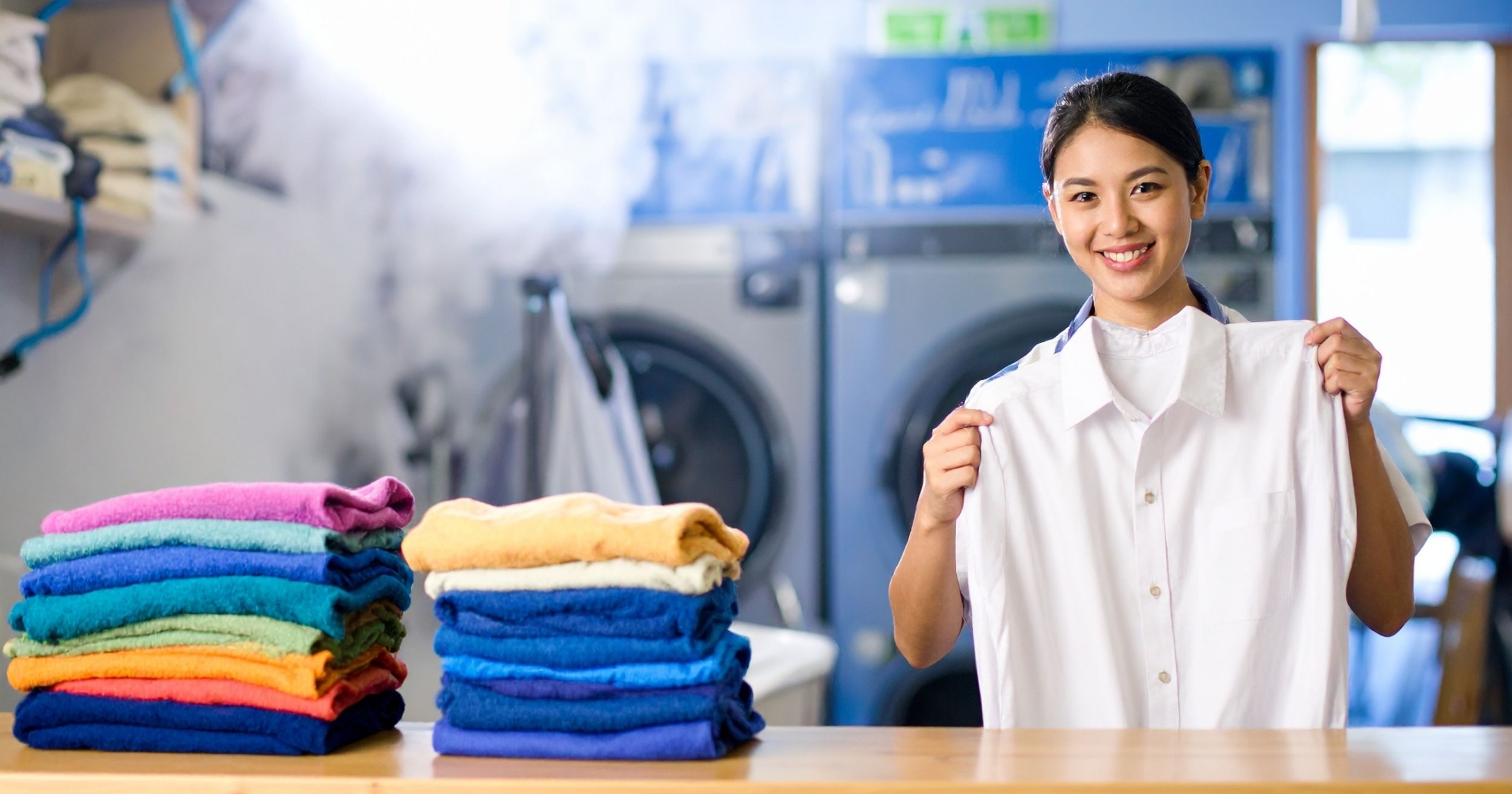 A woman holding shirt at laundry shop