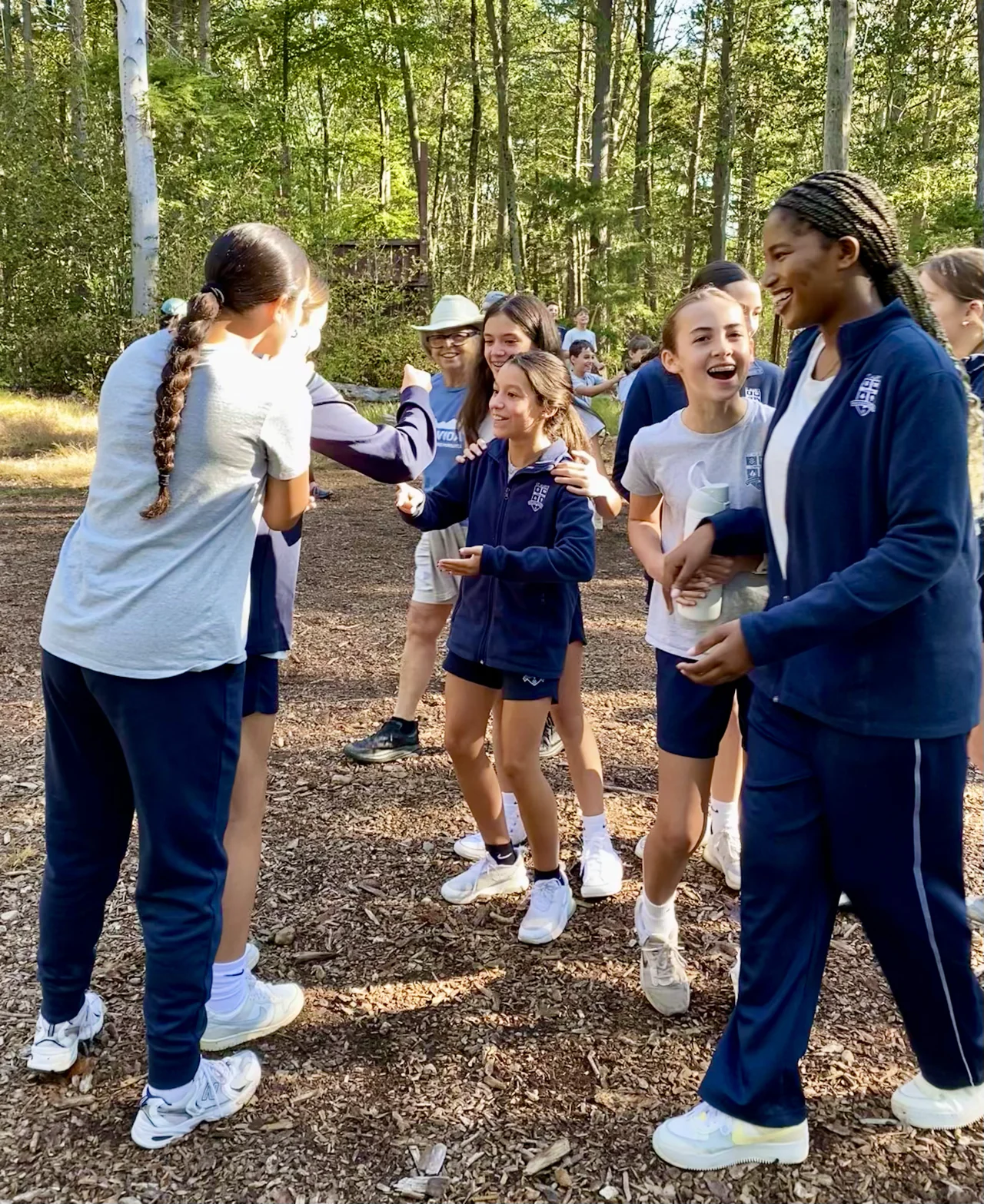 Students laughing together outdoors during an outdoor education trip