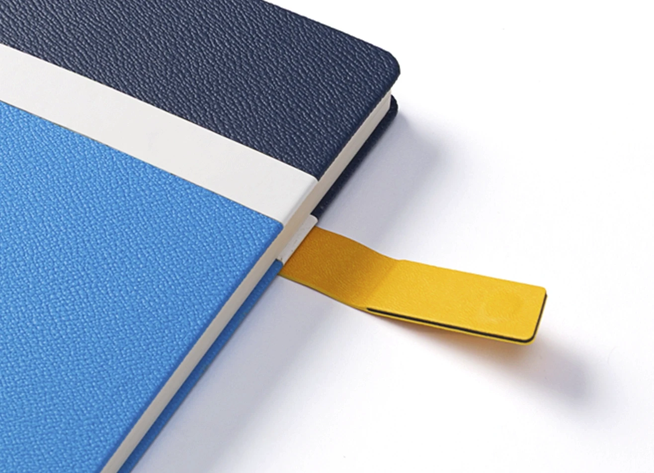 Close-up of notebook texture and yellow closure tab.