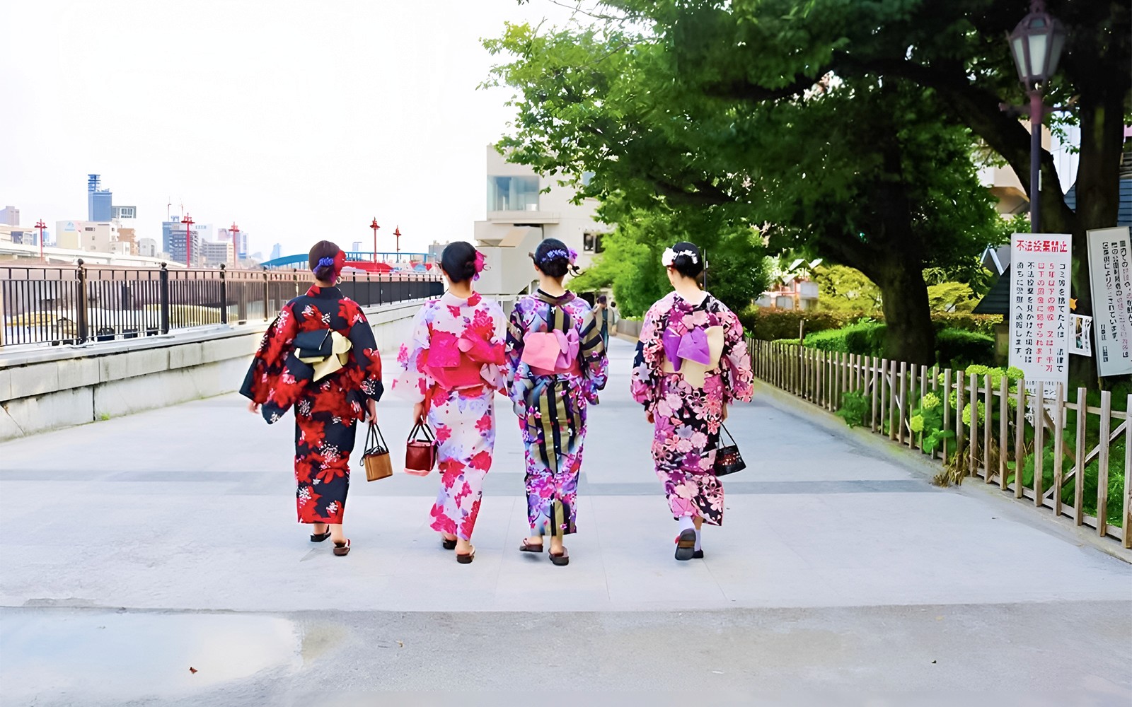 Tourist in traditional kimono walking through Asakusa, Tokyo, with Senso-ji Temple in the background.