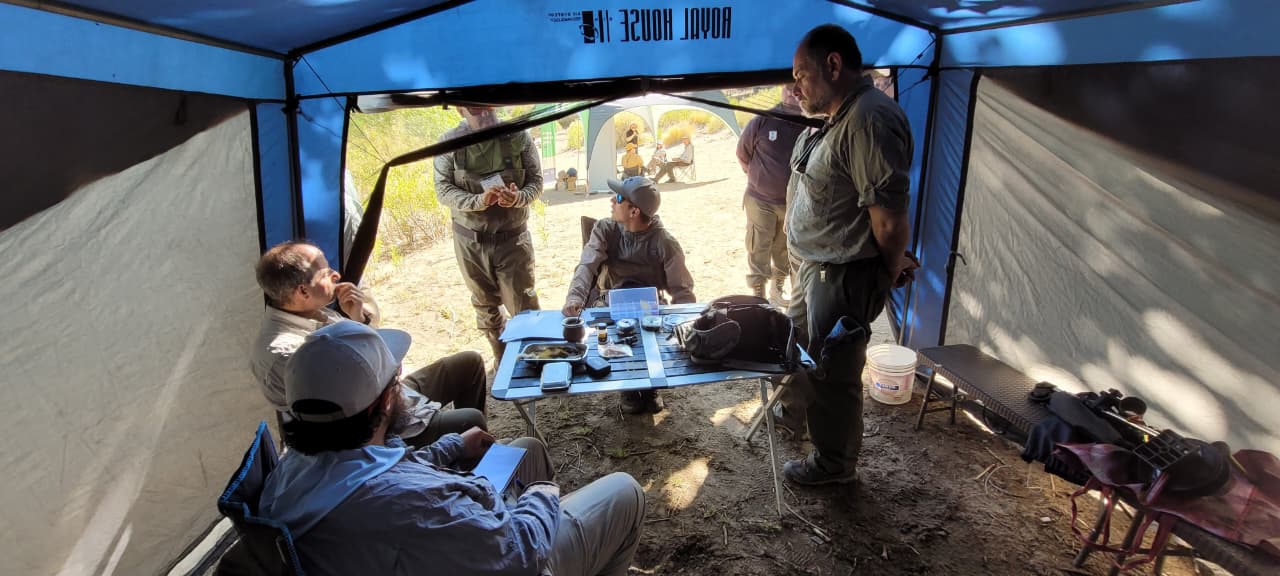 Grupo de pescadores almorzando algo dentro de una carpa