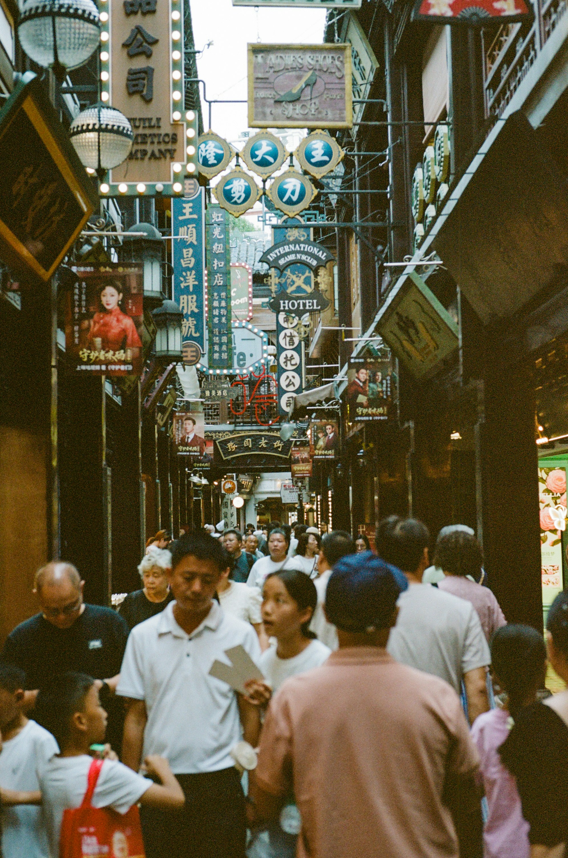 Crowded street with many signs and people.