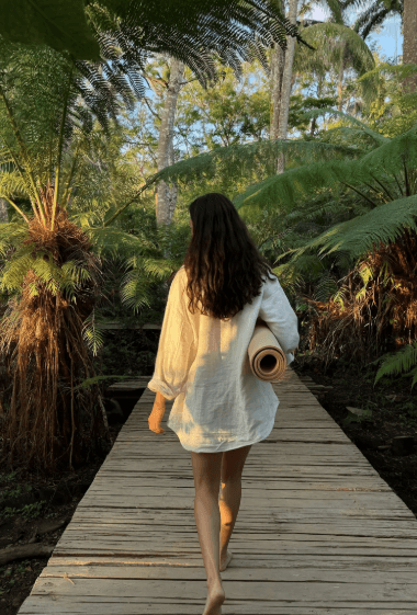 Beautiful woman looks upward with windblown hair in tropical forest.