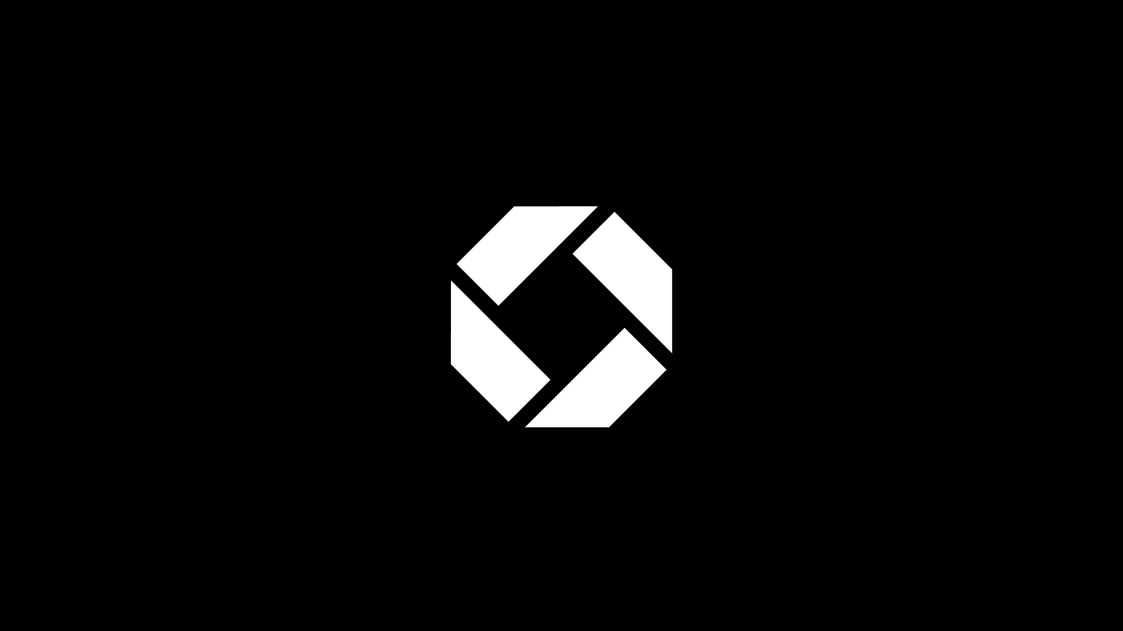 Modern home office setup with a monitor, ergonomic chair, keyboard, and indoor plants near a window with blinds.