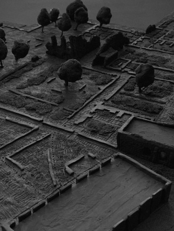 Modern interior with neutral tones, featuring seating areas, wooden floors, and large windows.