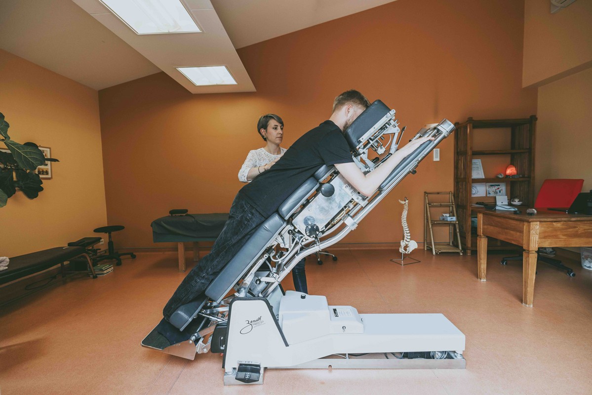 Mahiltde Hérault-Moreau, chiropracteur, effectuant un ajustement sur un patient positionné sur une table chiropratique inclinable, visant à améliorer l’alignement de la colonne vertébrale et à soulager les tensions musculaires.