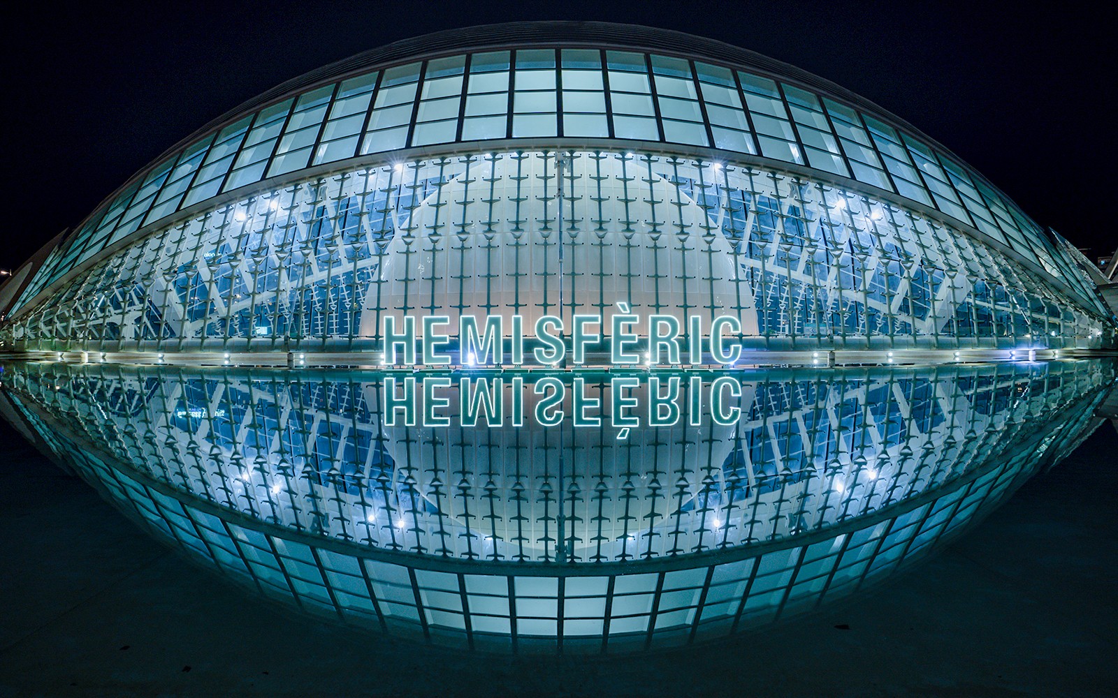 Hemisfèric building illuminated at night, Valencia, Spain.