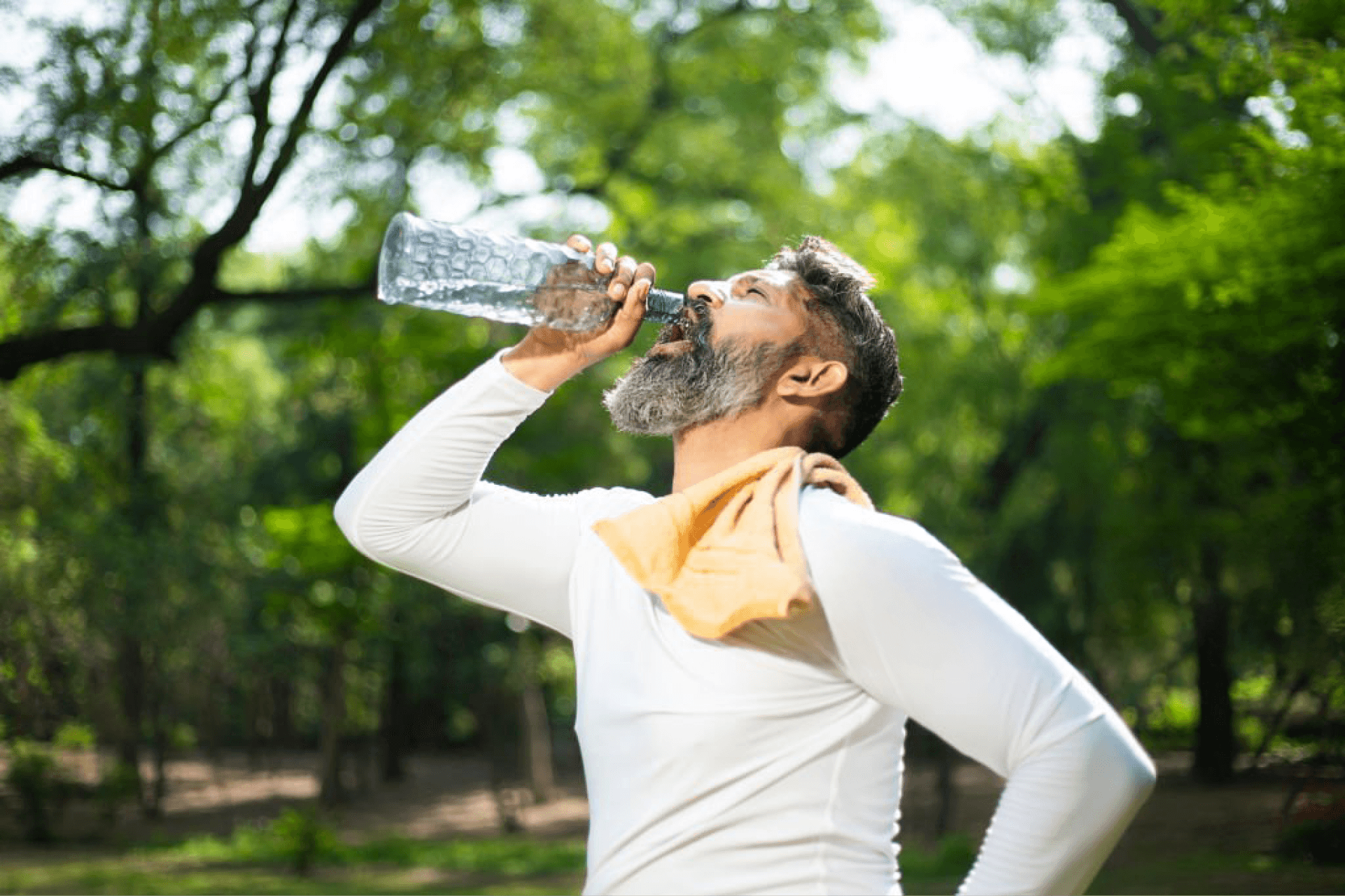 Man staying hydrated by drinking water after outdoor exercise.