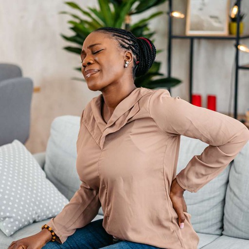 woman holding her lower back in pain