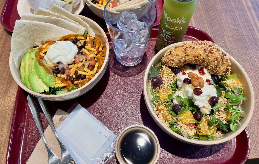 Chipotle beans with tortillas and bagel with cream cheese and salad for lunch with some drink and glass