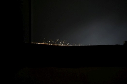 abstract rounded thin shapes in the dark are illuminated slightly from the right side
