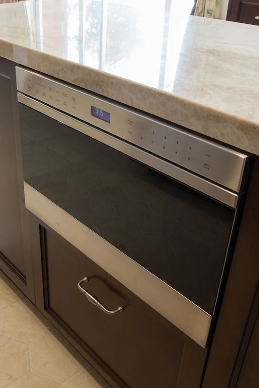 Modern kitchen featuring a stainless steel dishwasher integrated with dark wood cabinetry in Orange Interior Remodel.