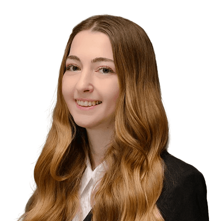 Nő portréja hosszú, hullámos hajjal, fekete zakóban, kék háttér előtt.