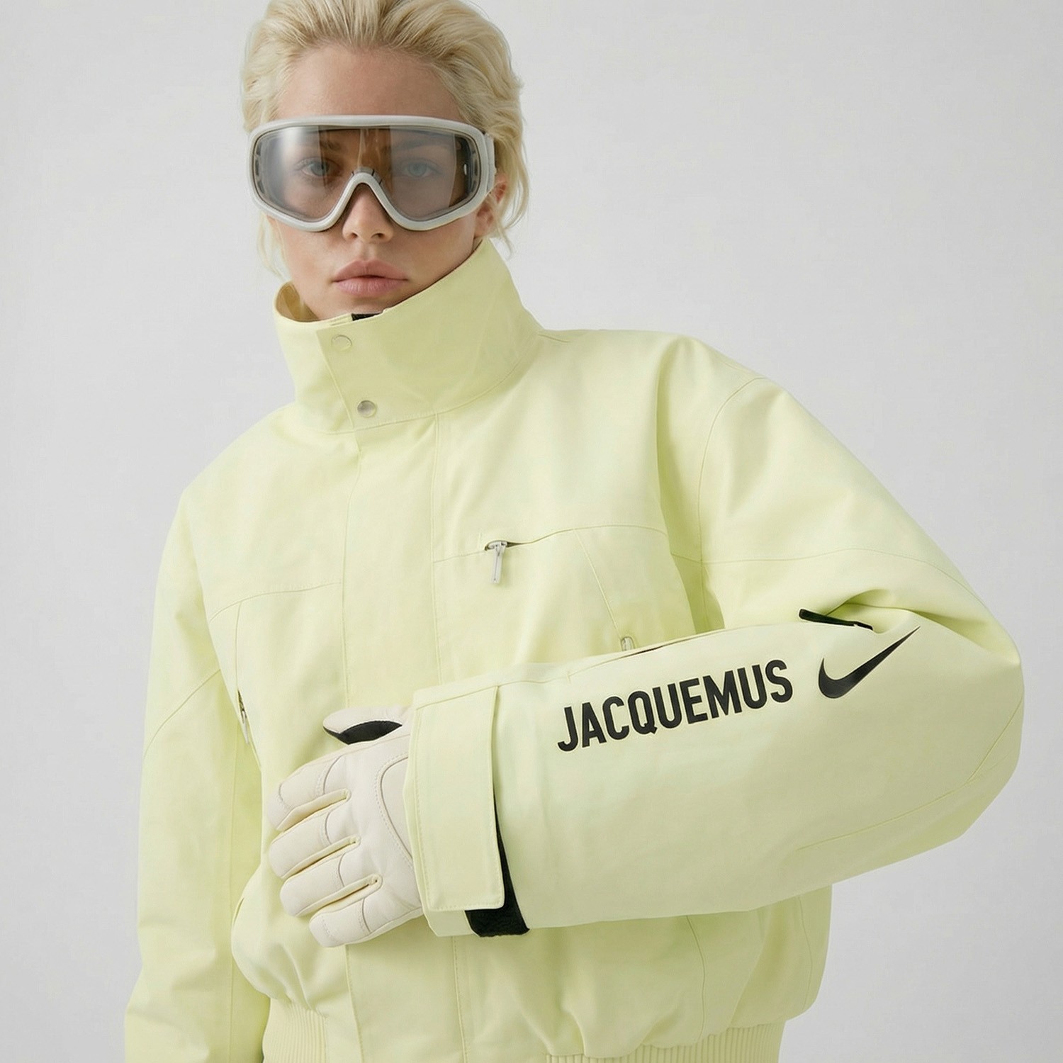 A close-up of a person wearing green-tinted glasses, with a serious expression and smooth skin.