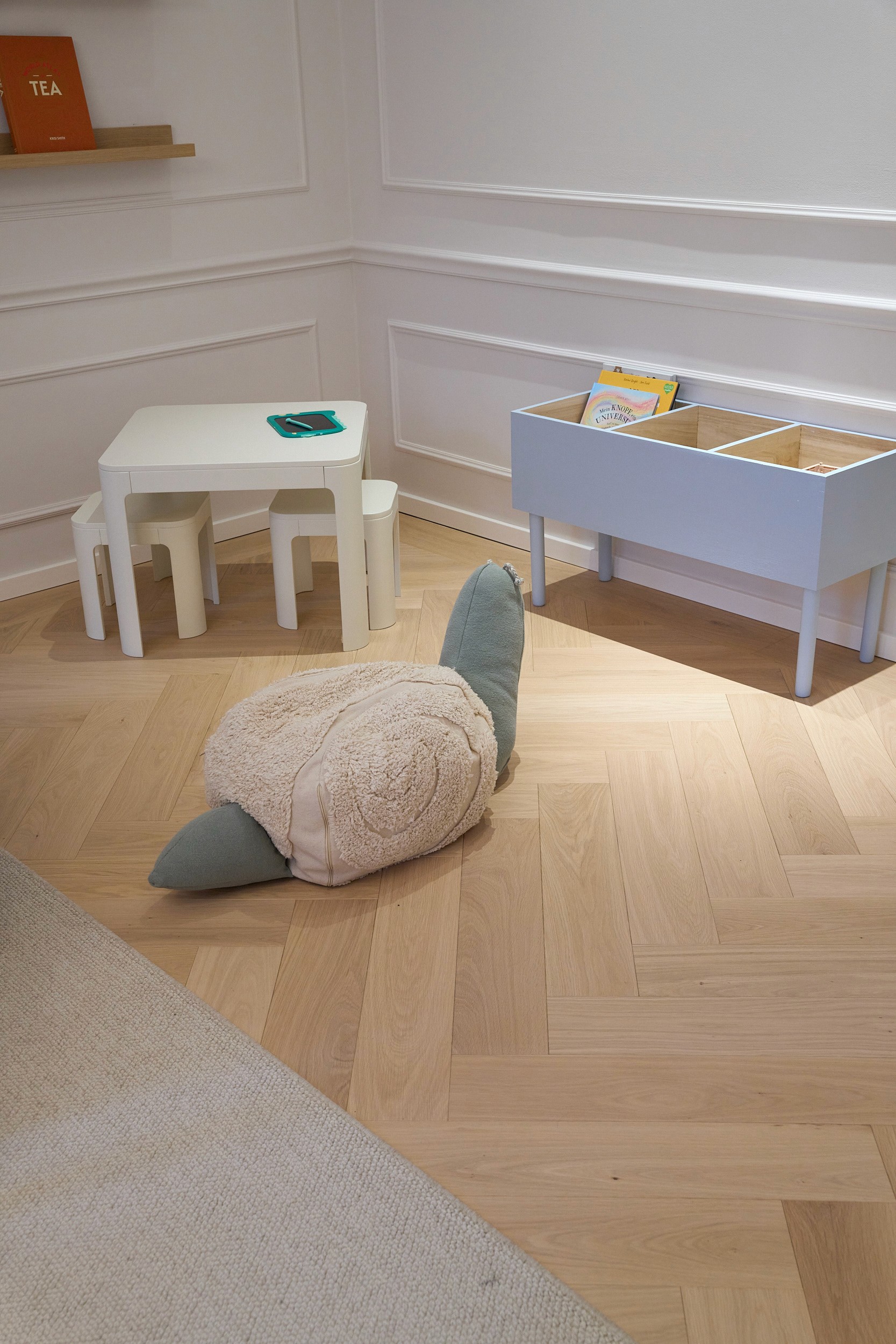 Kinderzimmer mit Schildkröten-Sitzkissen, kleinem Tisch und Bücherregal