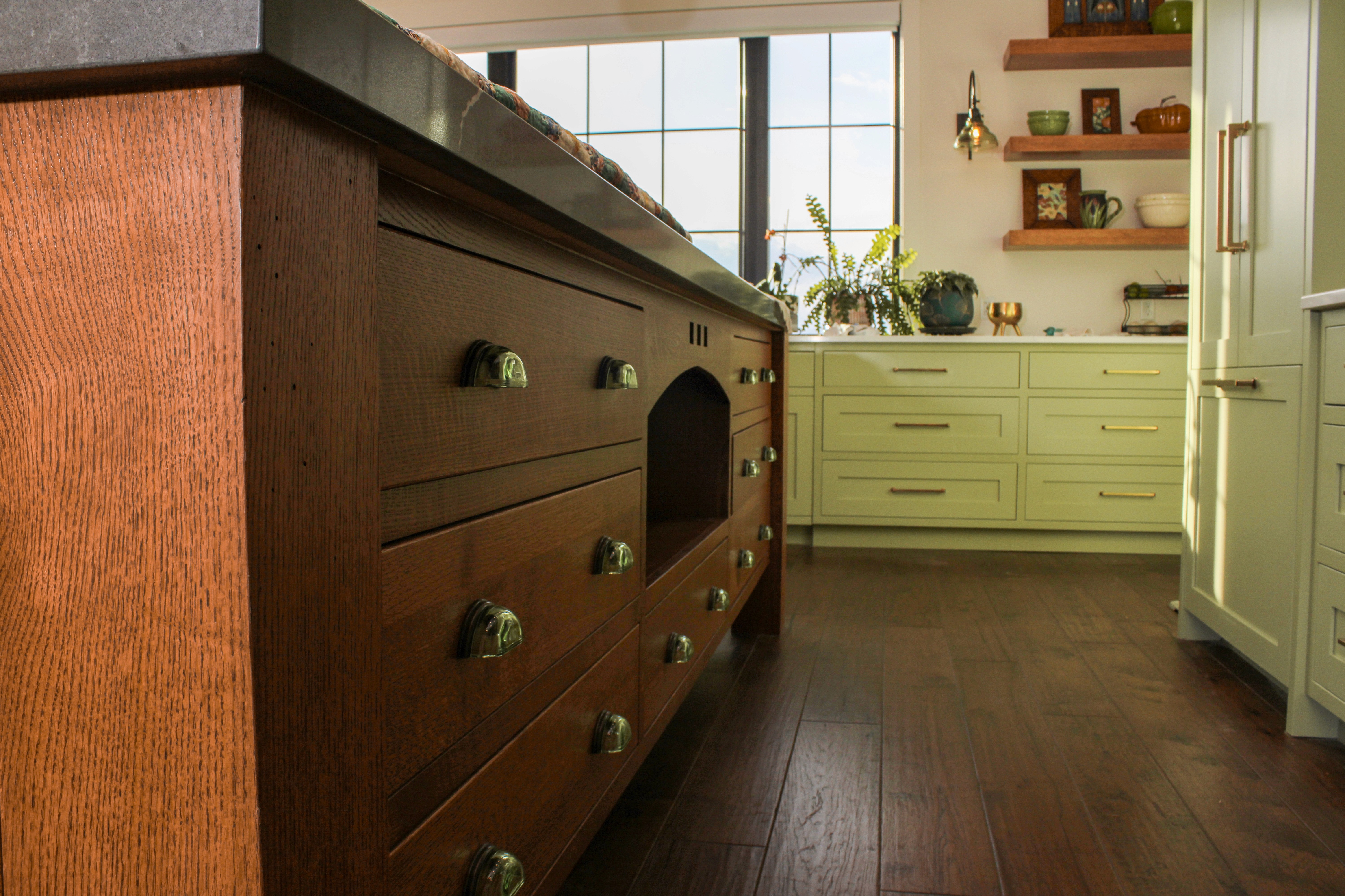 Green kitchen cabinetry with natural wood island and ample countertop space in a St. George Utah home remodel