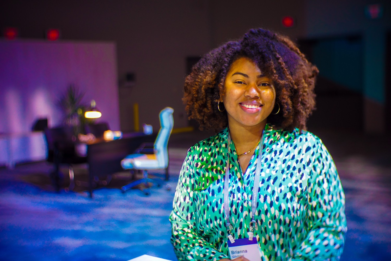 A close-up of a hand wearing multiple decorative rings against a blue background.