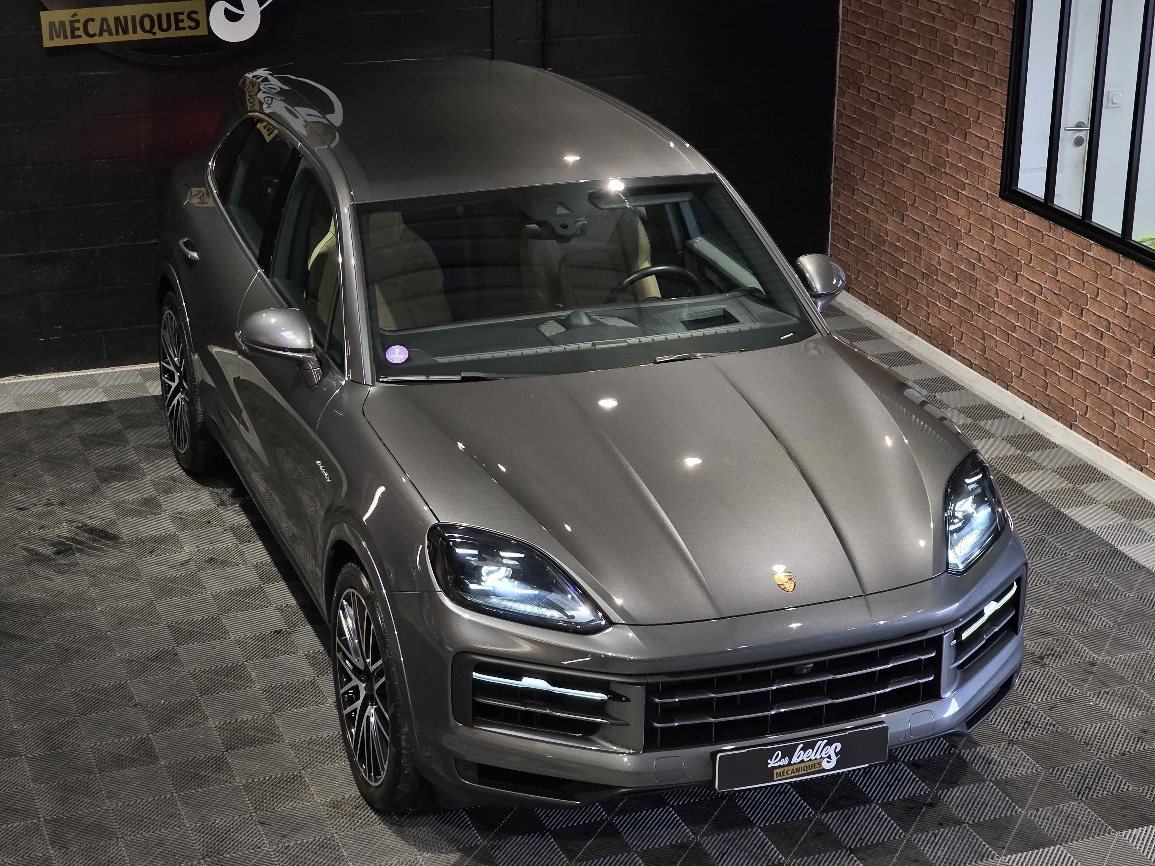 Porsche Cayenne E-Hybrid gris vu de dessus, capot musclé et toit vitré, showroom Les Belles Mécaniques Martignas-sur-Jalle