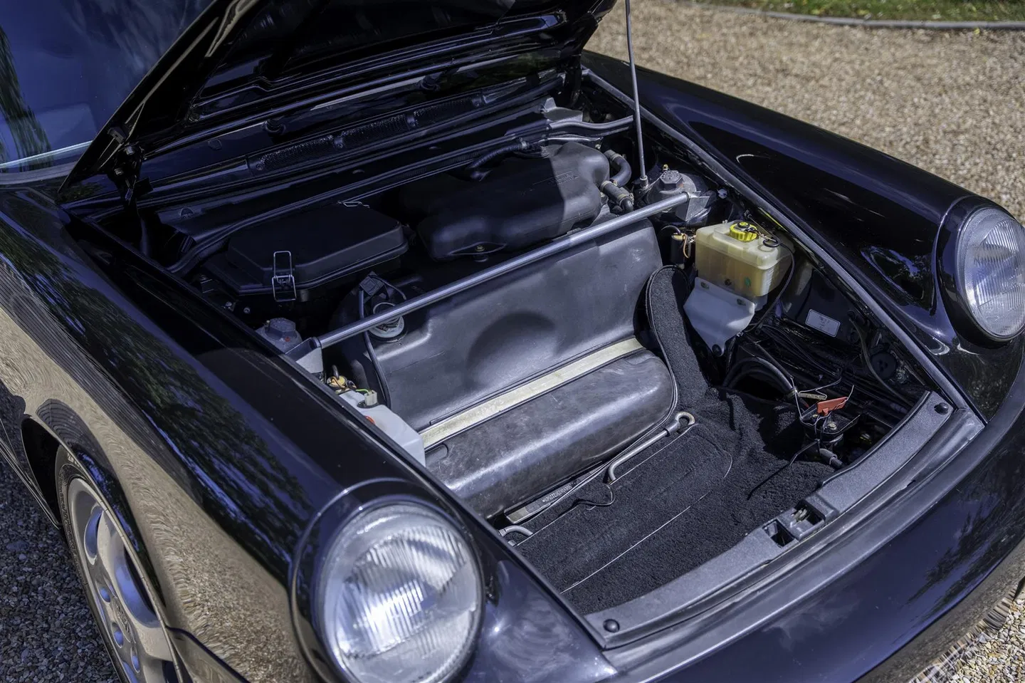 Open alloy bonnet showing the front luggage area and brake reservoir