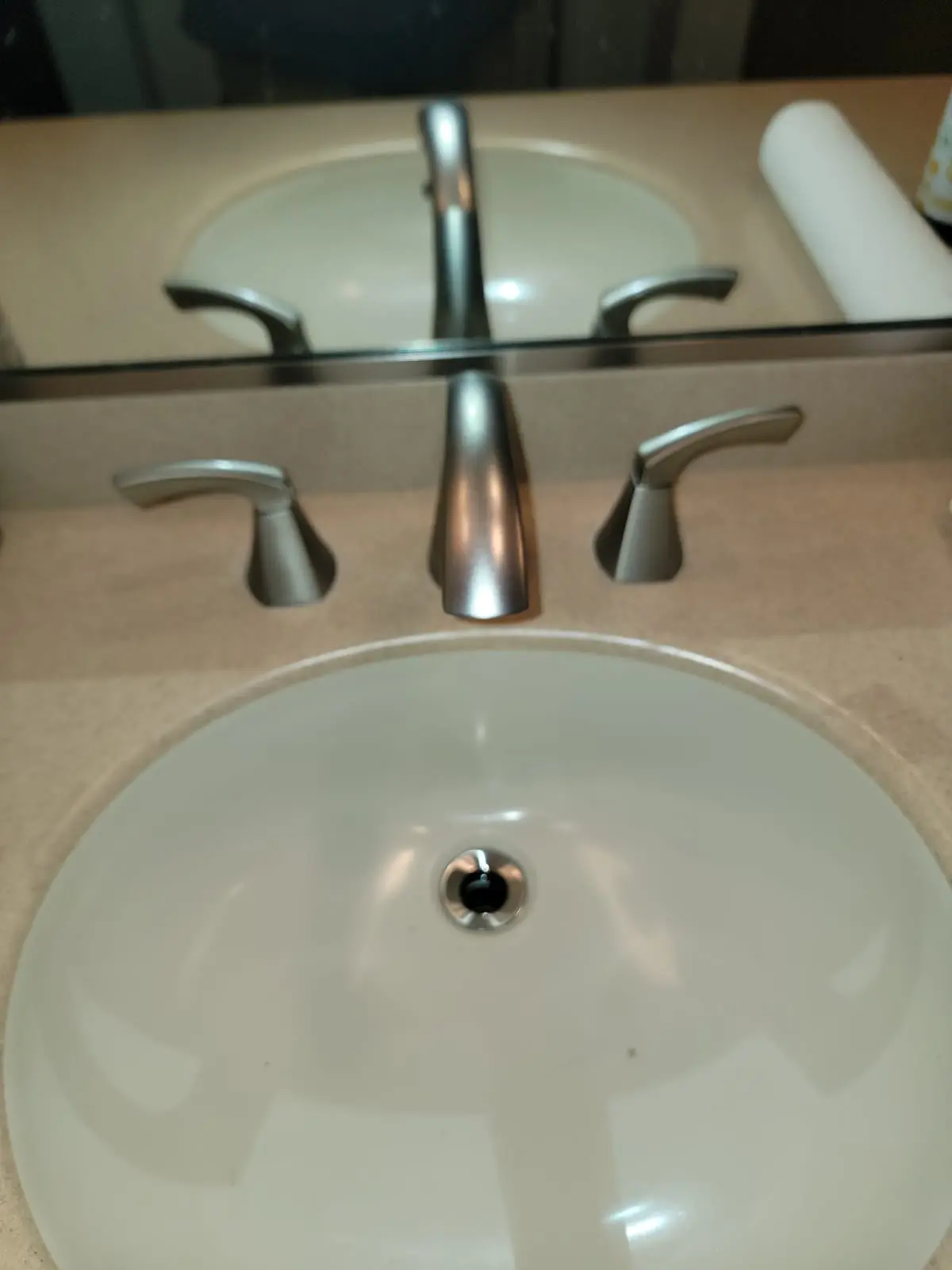 A modern double-handle bathroom faucet and clean porcelain sink, showcasing our professional faucet and sink installation services.