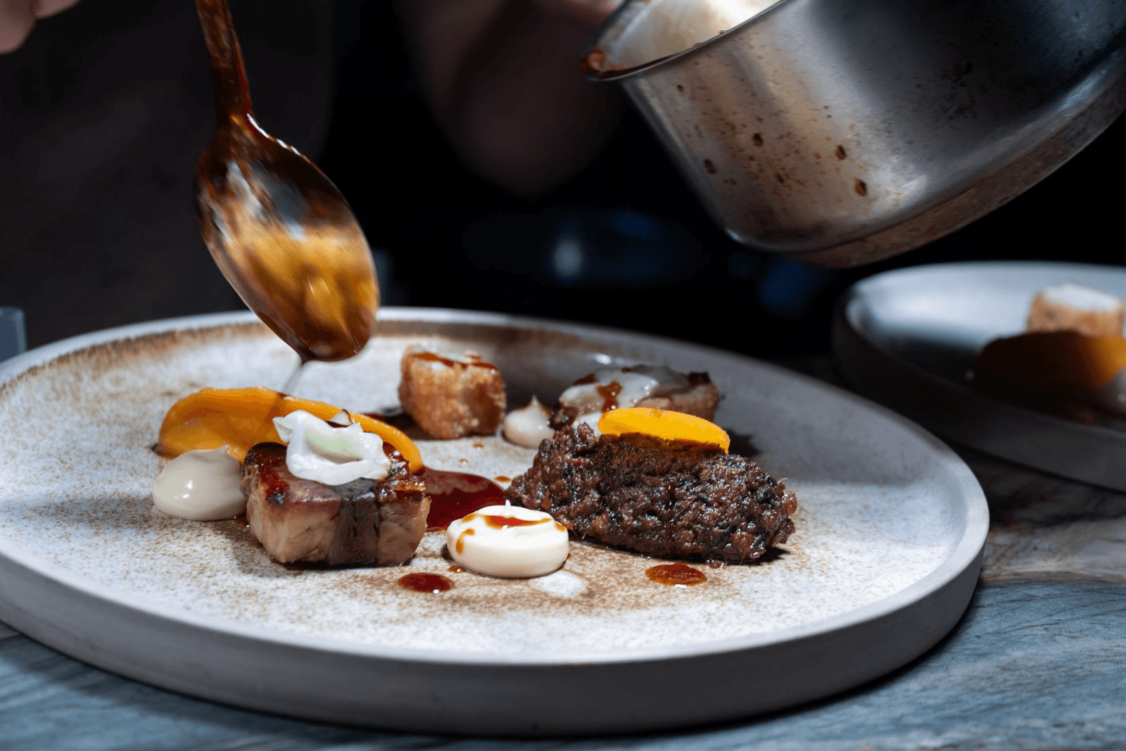 Modern cafe interior with tables, chairs, and plants.