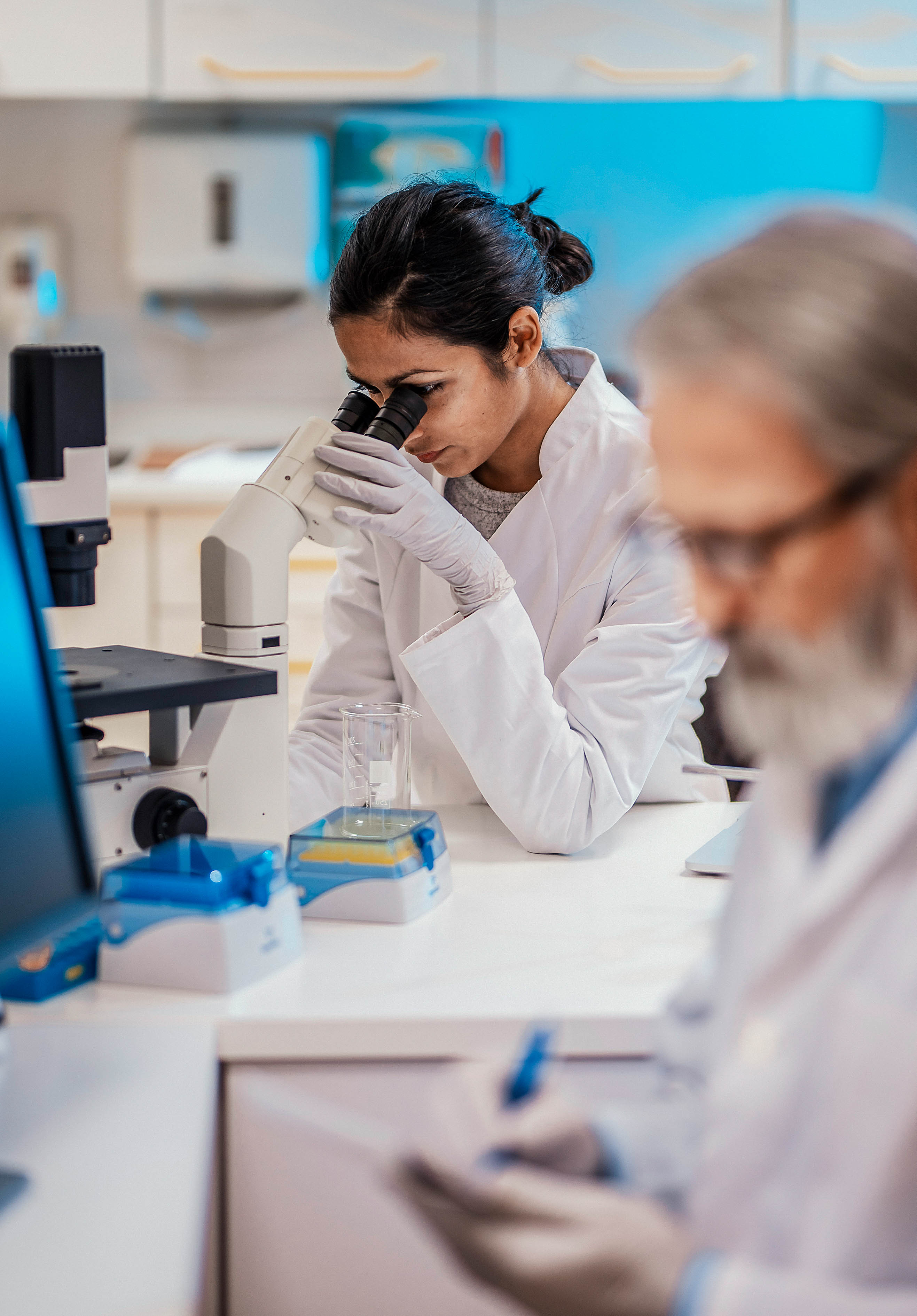 young female scientist looking through a microscope