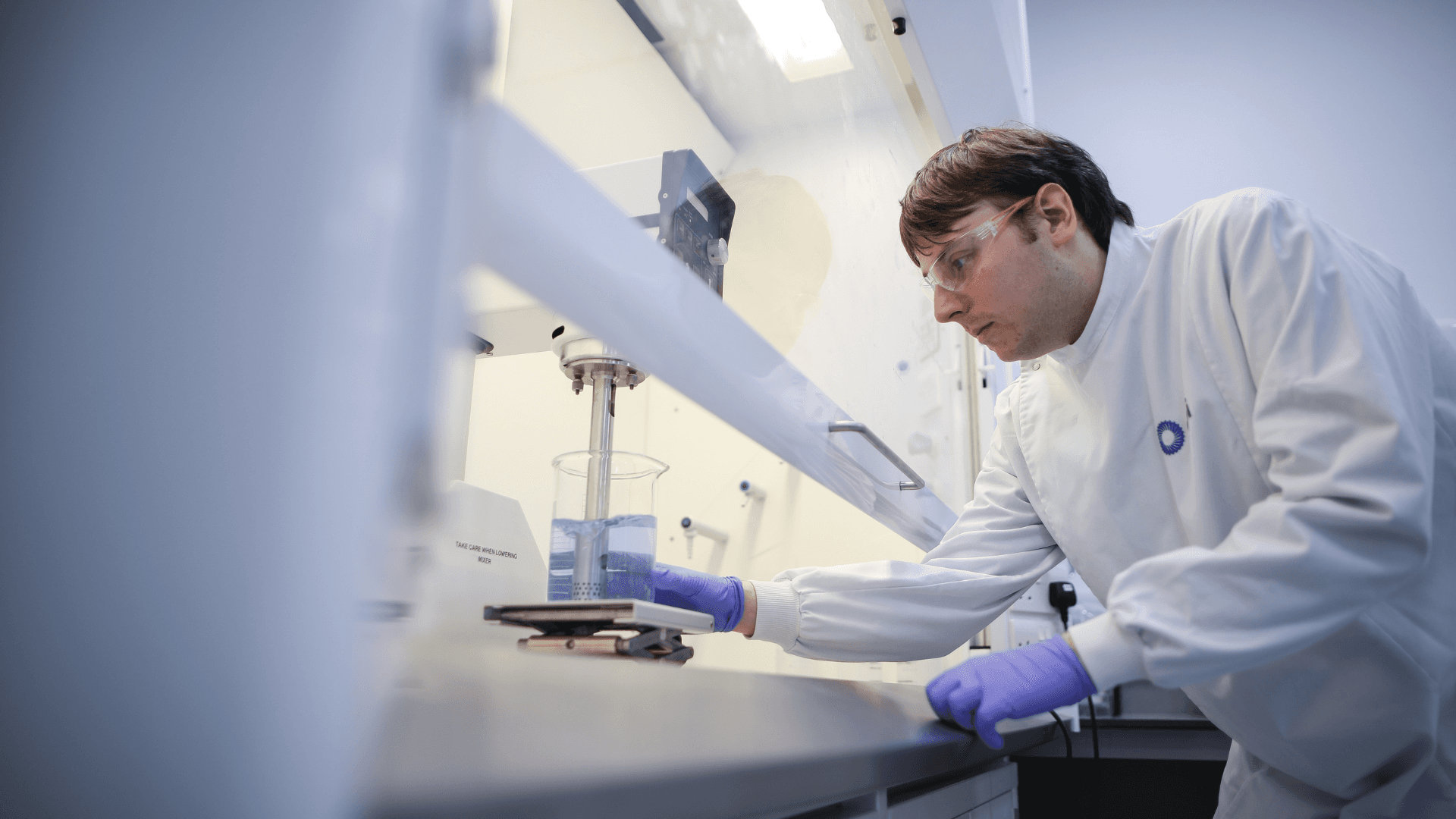 CPI expert mixing liquid in a beaker at CPI lab. 