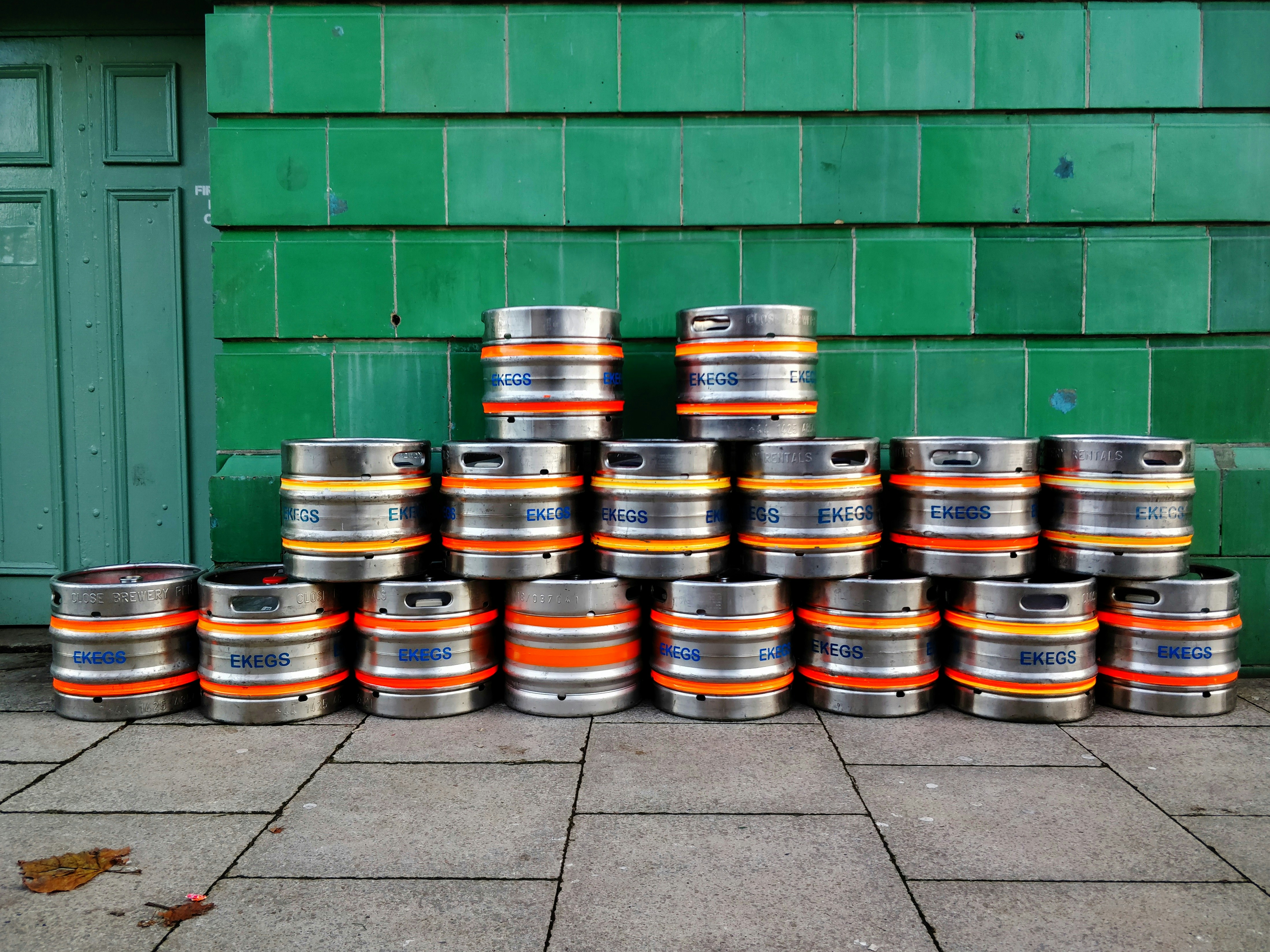 Kegs stacked against a green wall and doorway.