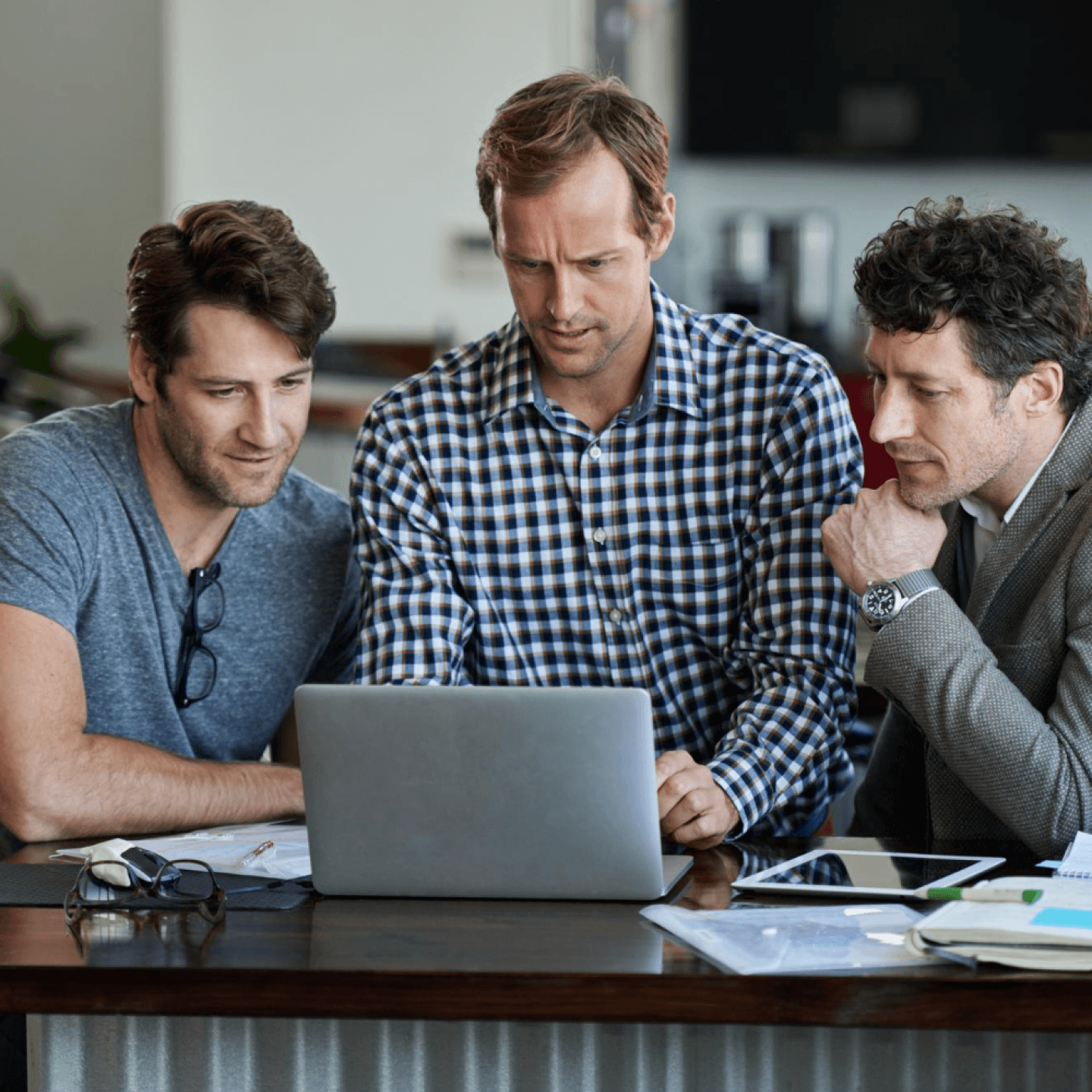 Three people reviewing a laptop together at a table