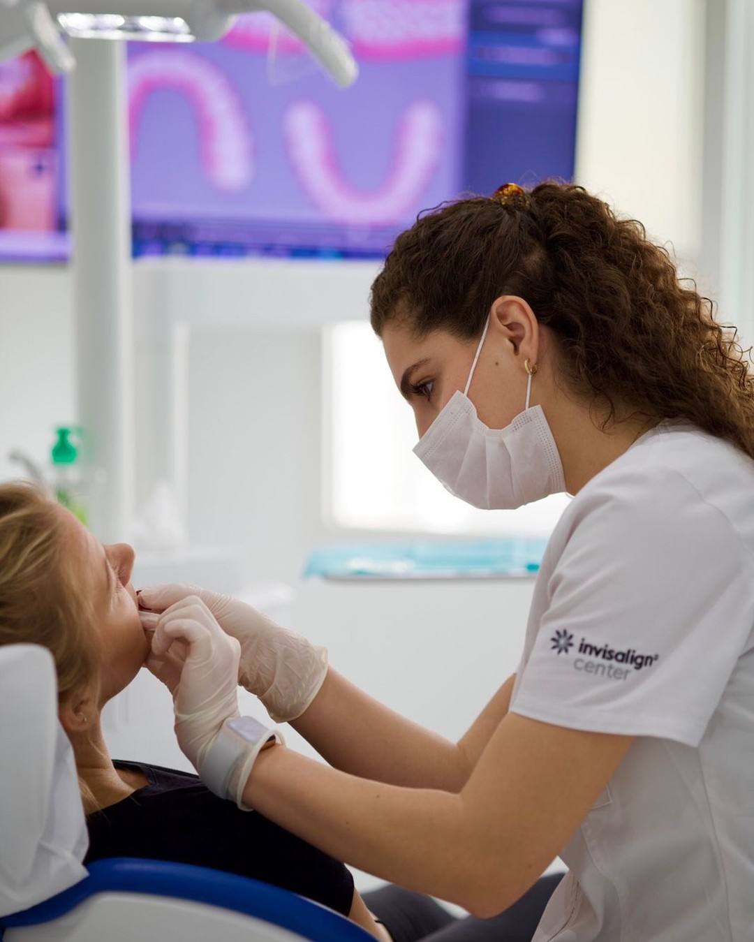 علاج انقطاع النفس أثناء النوم بمساعدة طبيبة أسنان تساعد المريضة على تركيب الجهاز الفموي لتحسين النوم، مع ضمان الاستخدام الليلي الصحيح.